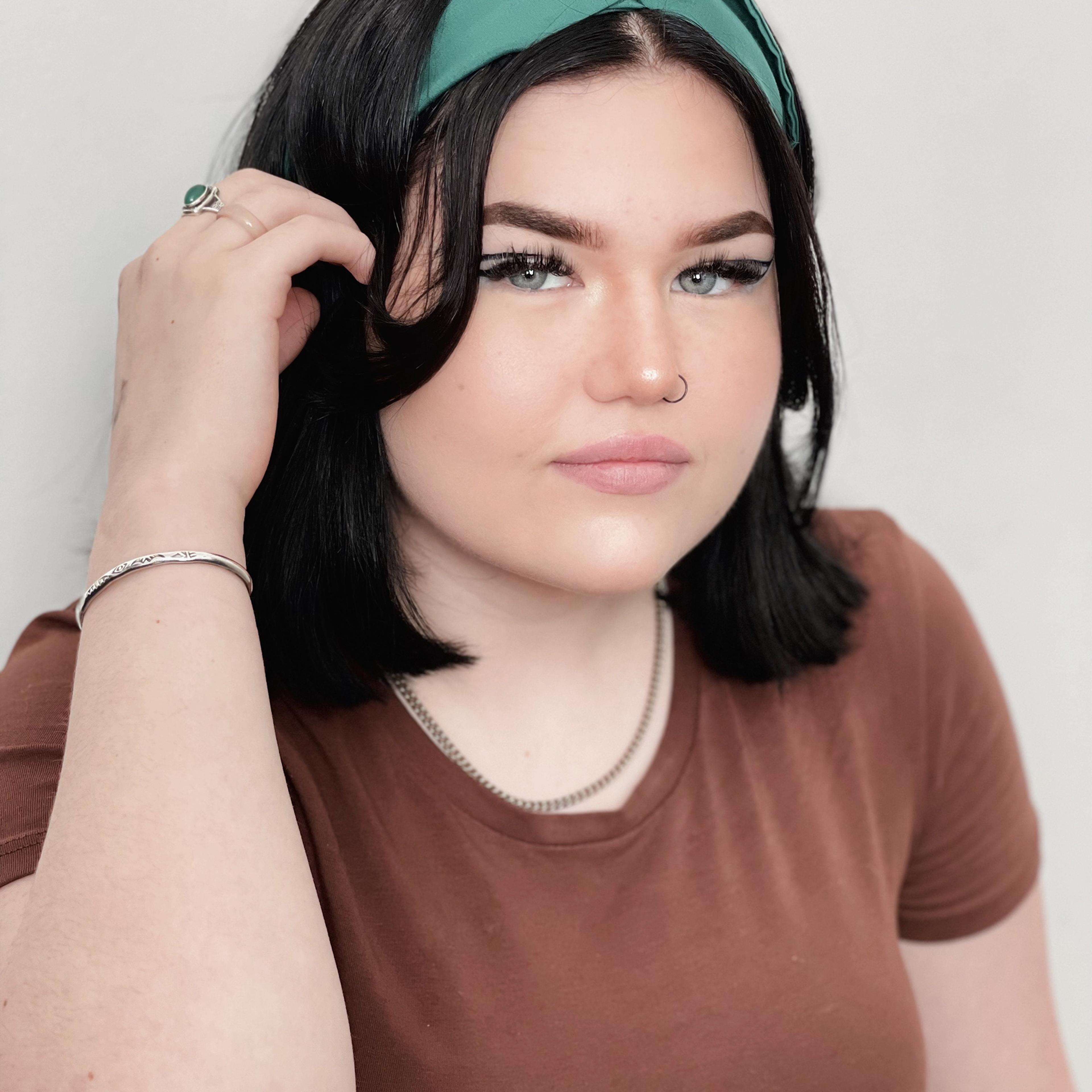Mae Stephens tucking her hair behind her ear
