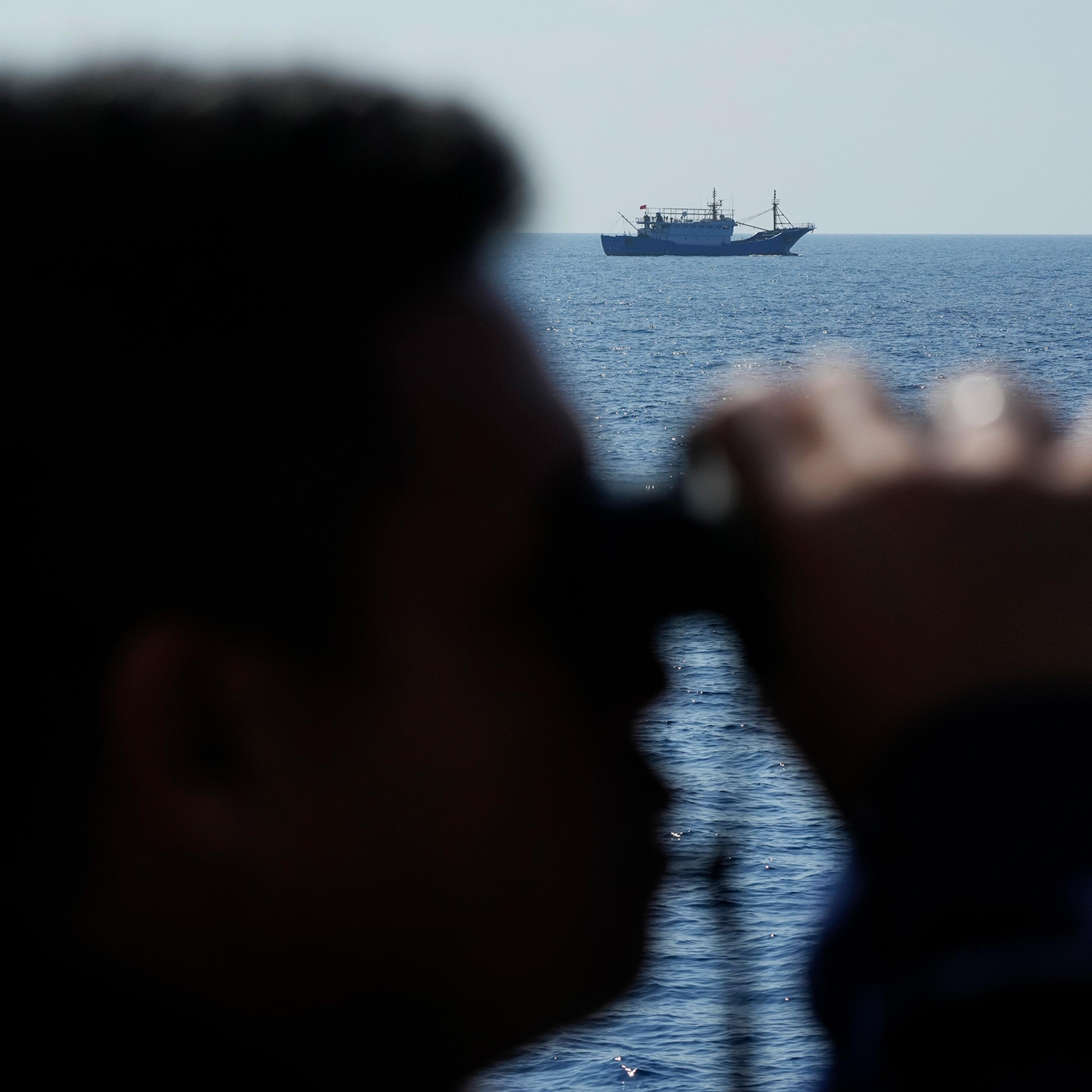 A suspected Chinese militia ship passes as members onboard the Philippine Coast Guard BRP Malabrigo drives them away from Philippine-occupied areas in the South China Sea on April 21.