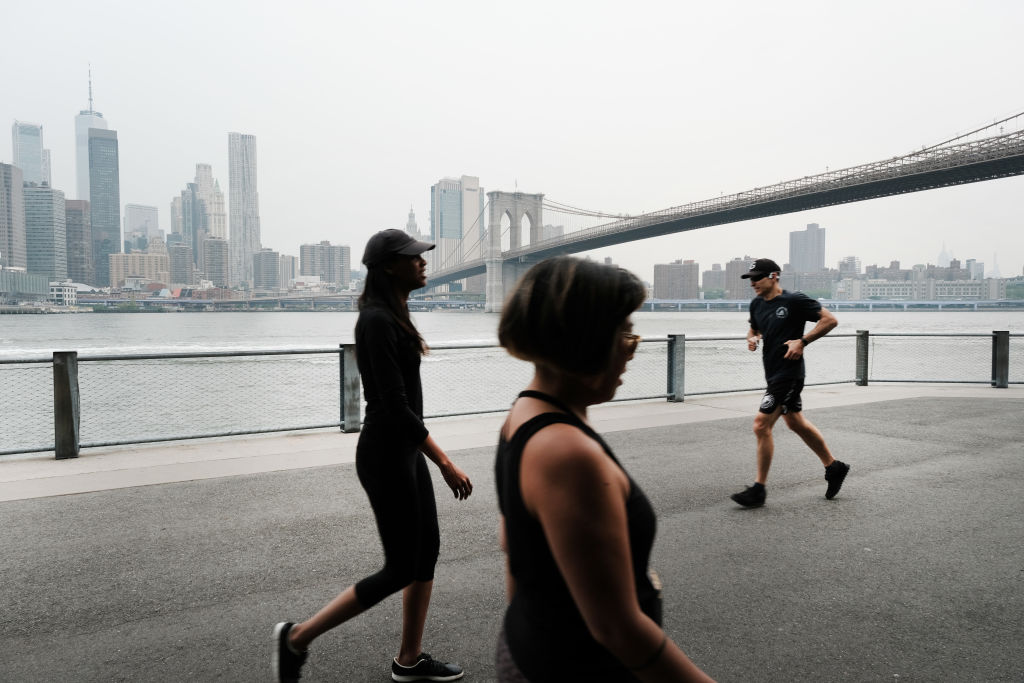 People walk through a Brooklyn Park on a hazy morning resulting from Canadian wildfires on June 6, 2023 in New York City. Over 100 wildfires are burning in the Canadian province of Nova Scotia and Quebec causing air quality health alerts for New York Sta