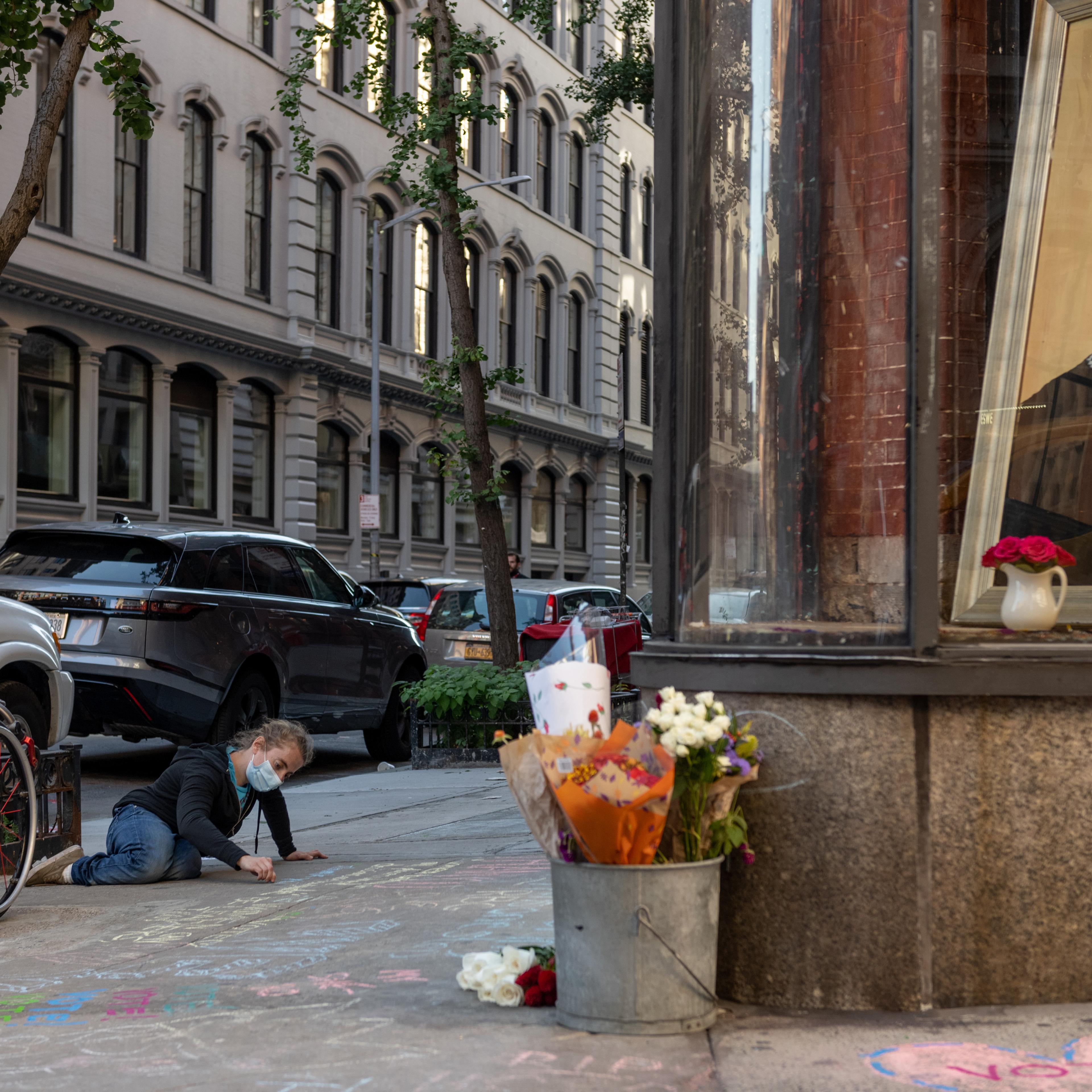 A woman wearing a mask writes a message in chalk in front of a painting of the late Associate Justice of the Supreme Court Ruth Bader Ginsburg on Sept. 19 in New York City. Ginsburg died on Sept. 18.