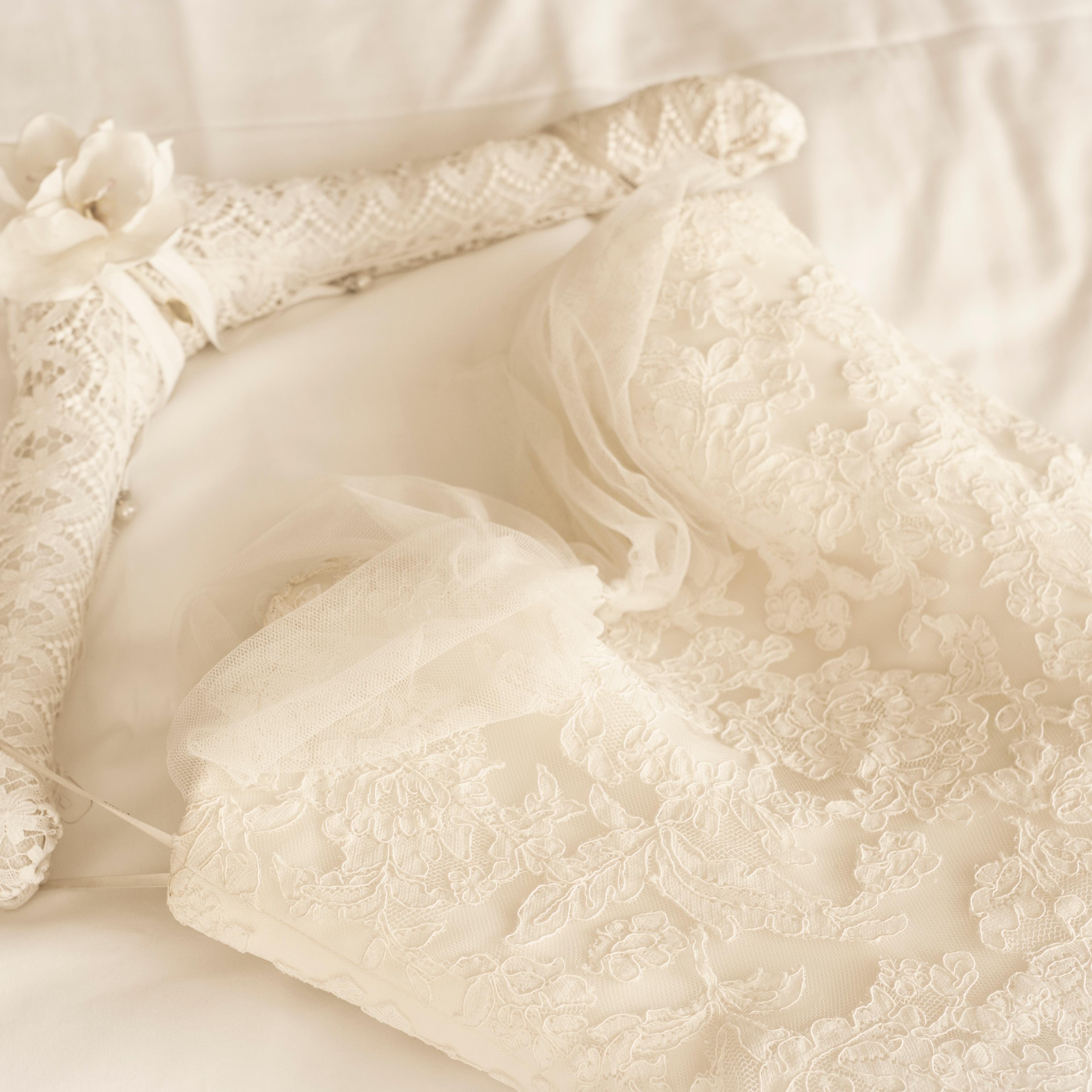 Germany, Lace wedding dress lying on bed