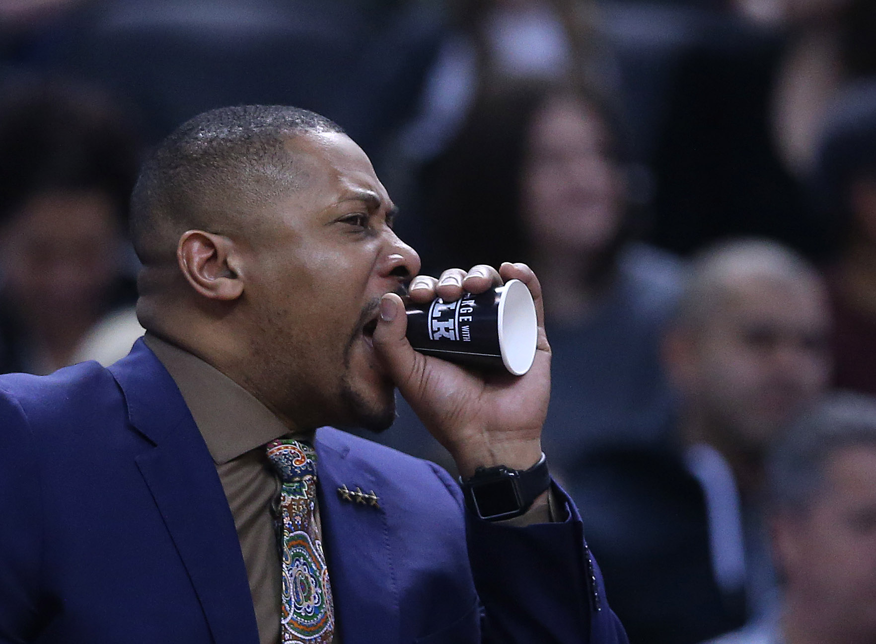 Toronto Raptors assistant coach Jamaal Magloire uses a paper cup as a megaphone to shout instructions to the defense at Scotiabank Arena in Toronto, March 24, 2019.