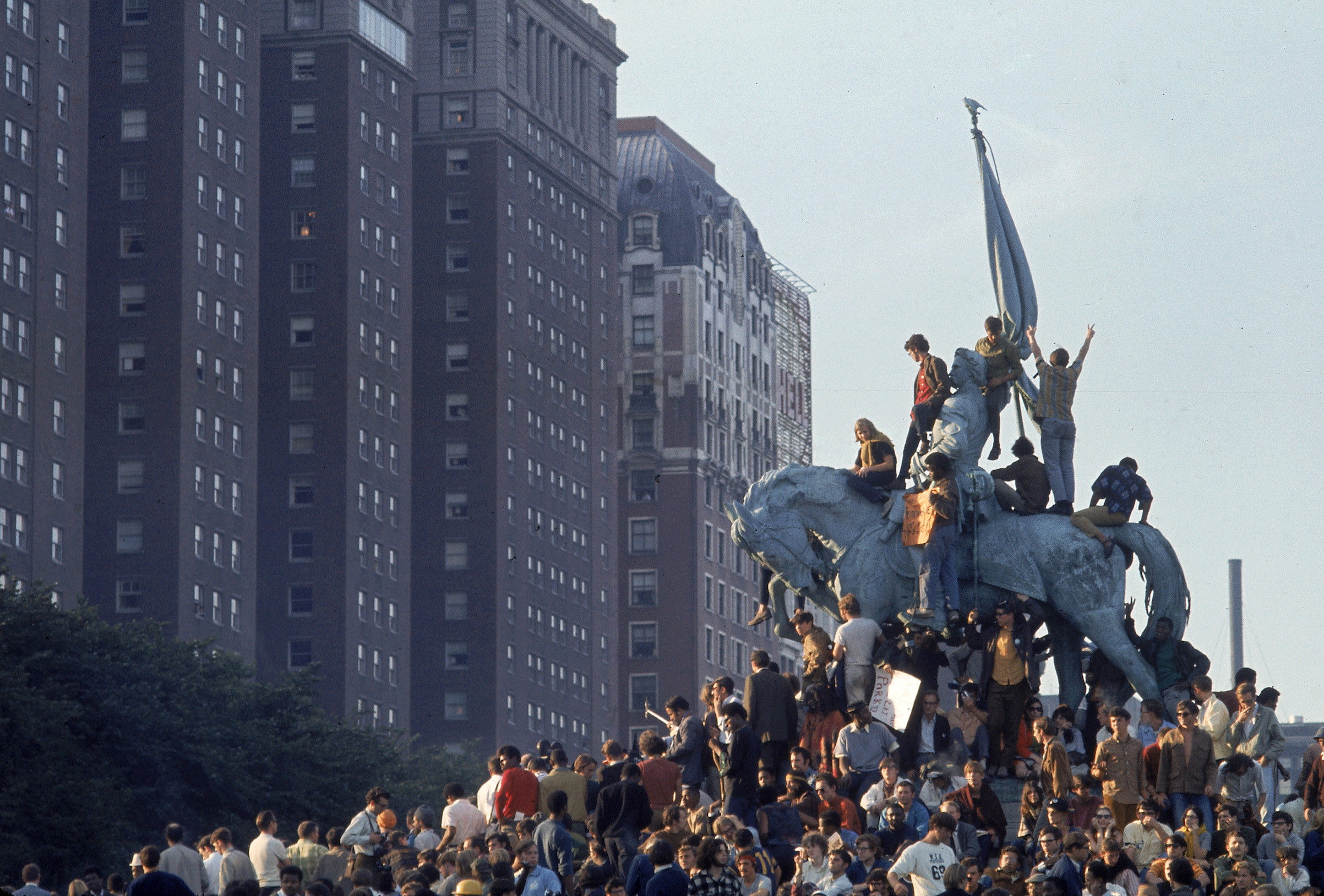 Yippie demonstrators swarming a statue in Grant Park