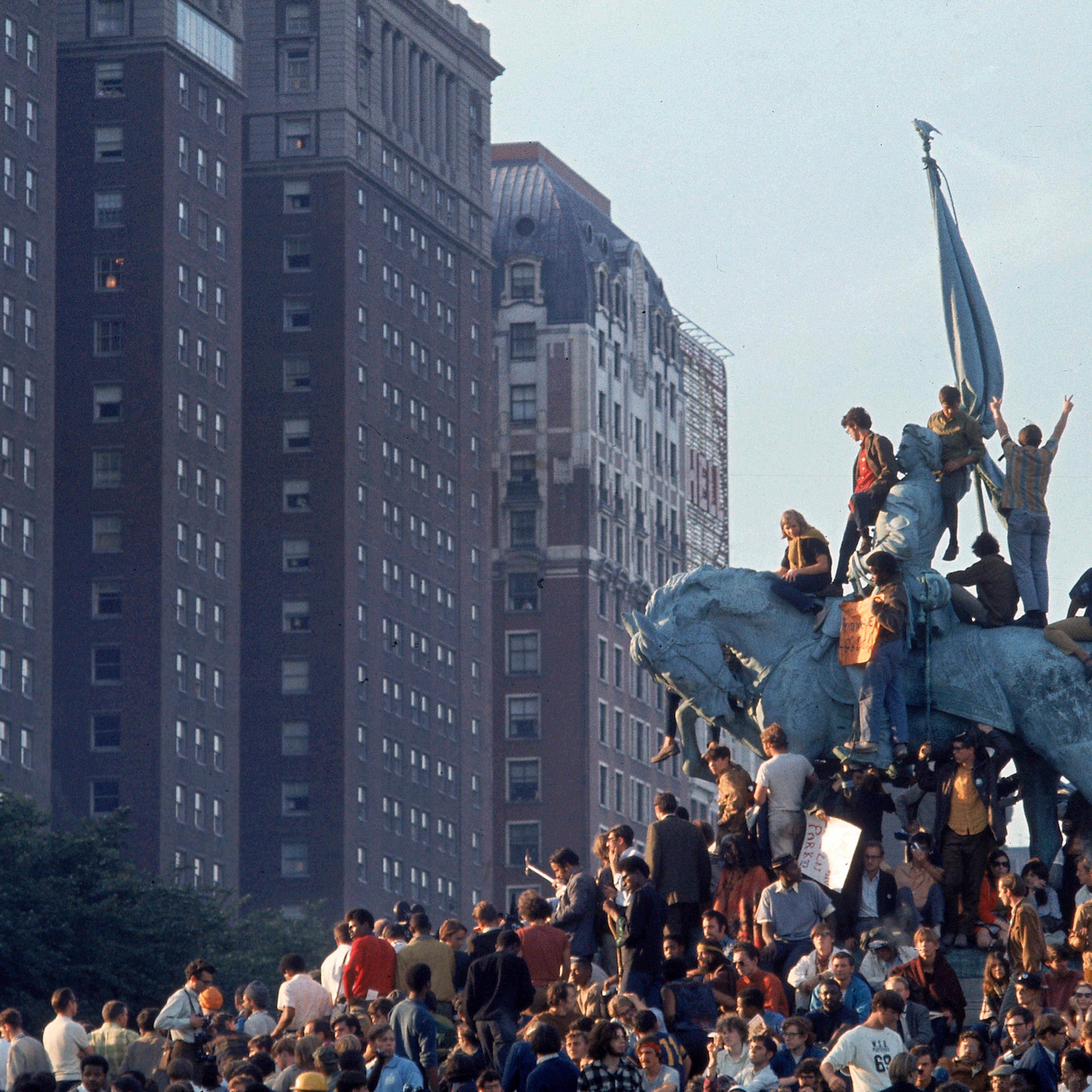 Yippie demonstrators swarming a statue in Grant Park