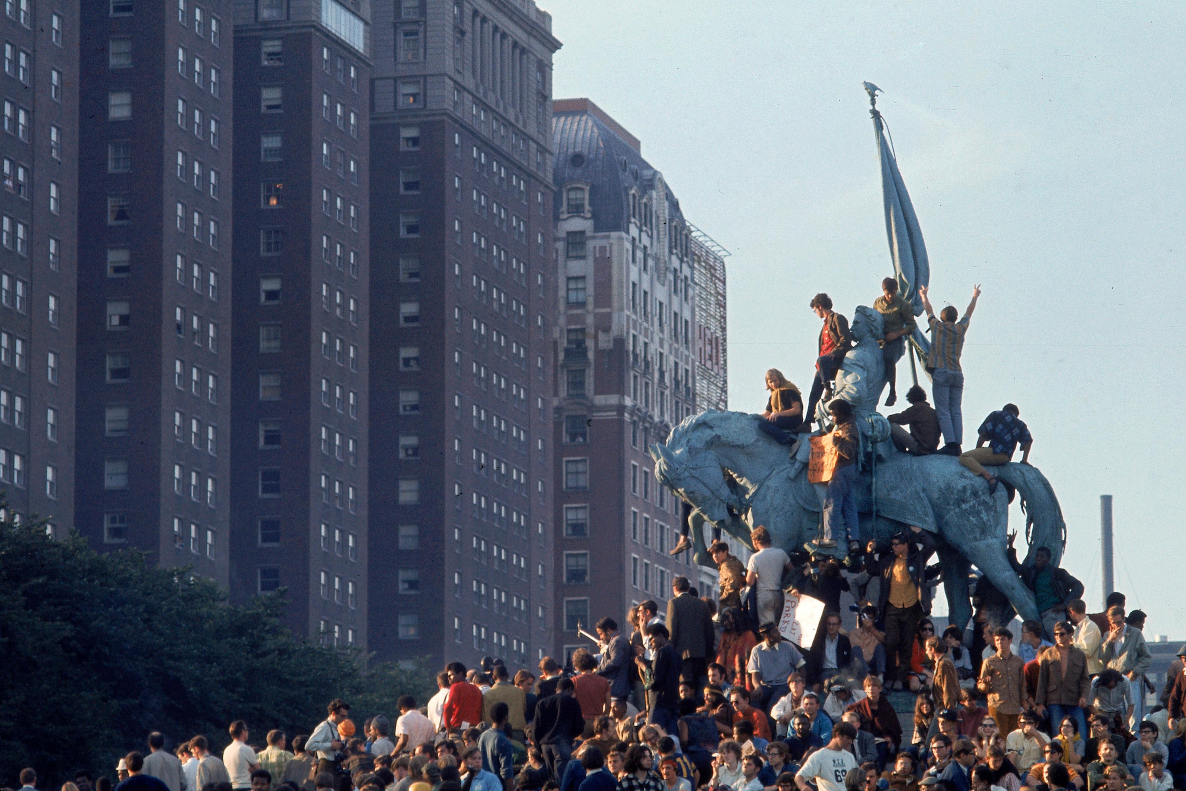 Yippie demonstrators swarming a statue in Grant Park