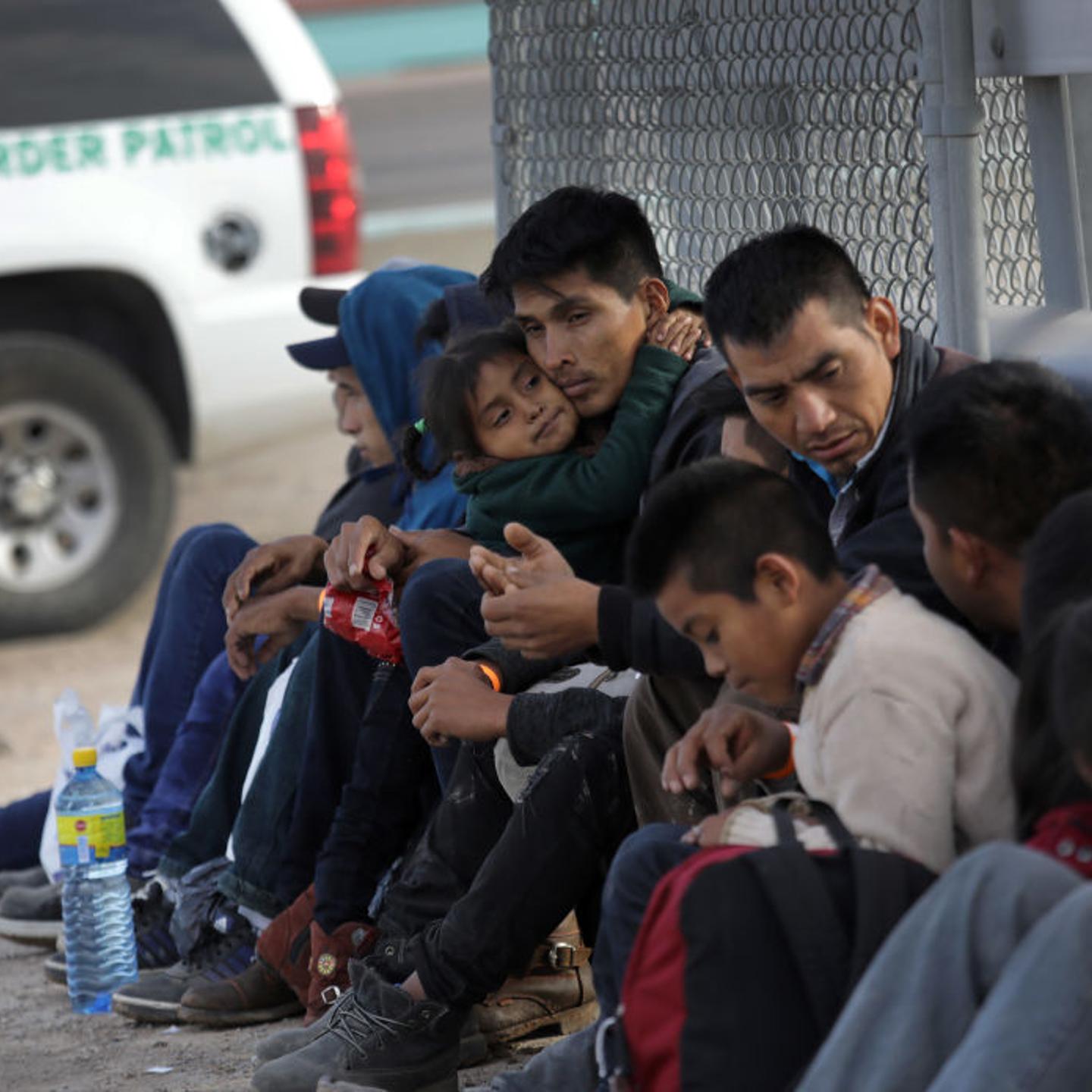 Central American migrants wait to be taken into custody and turning themselves in for political asylum after crossing into the United States