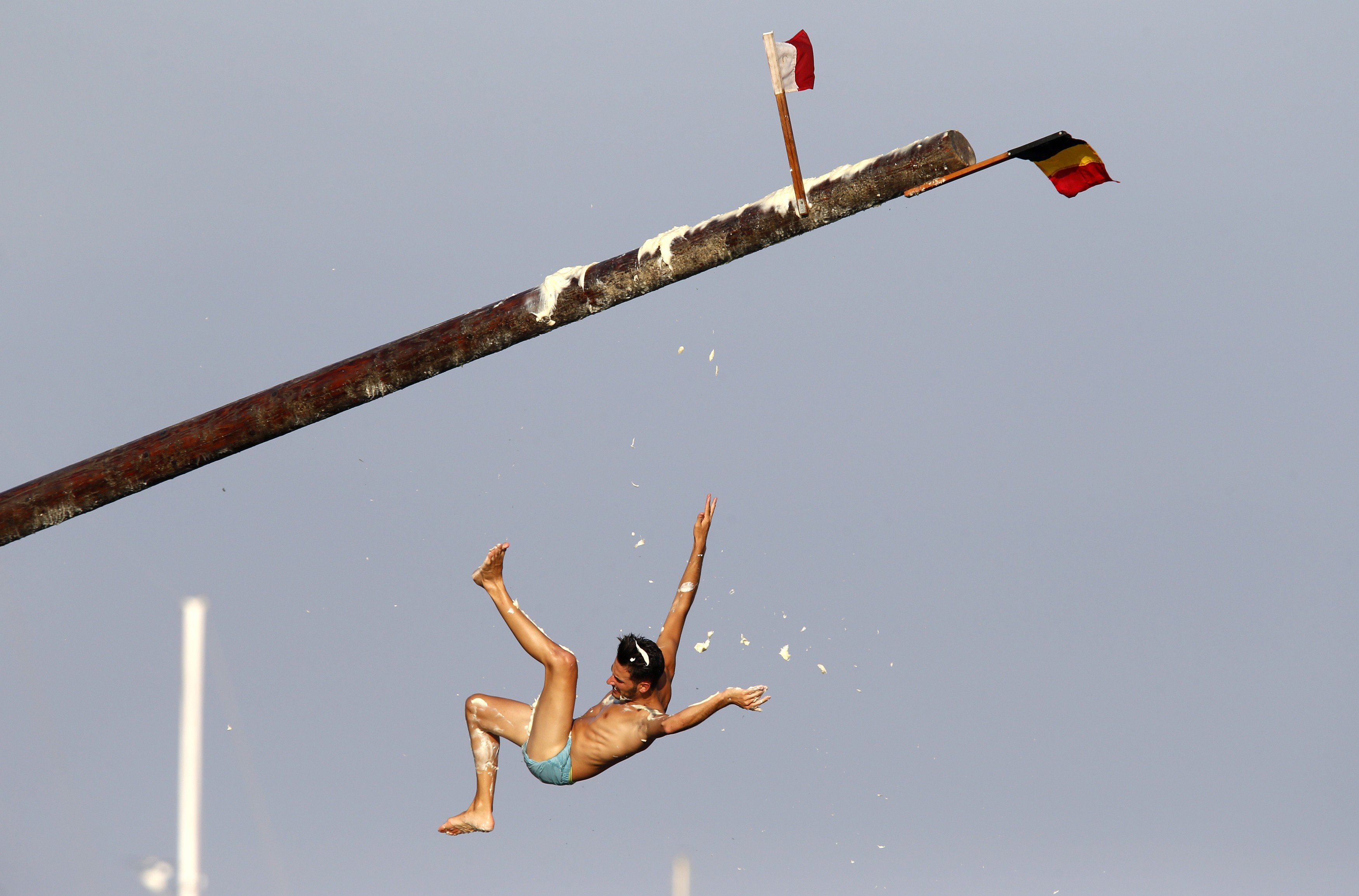 A man falls off the "gostra", a pole covered in grease, during the celebrations for the religious feast of St Julian, patron of the town of St Julian's, outside Valletta on Aug. 31, 2014.