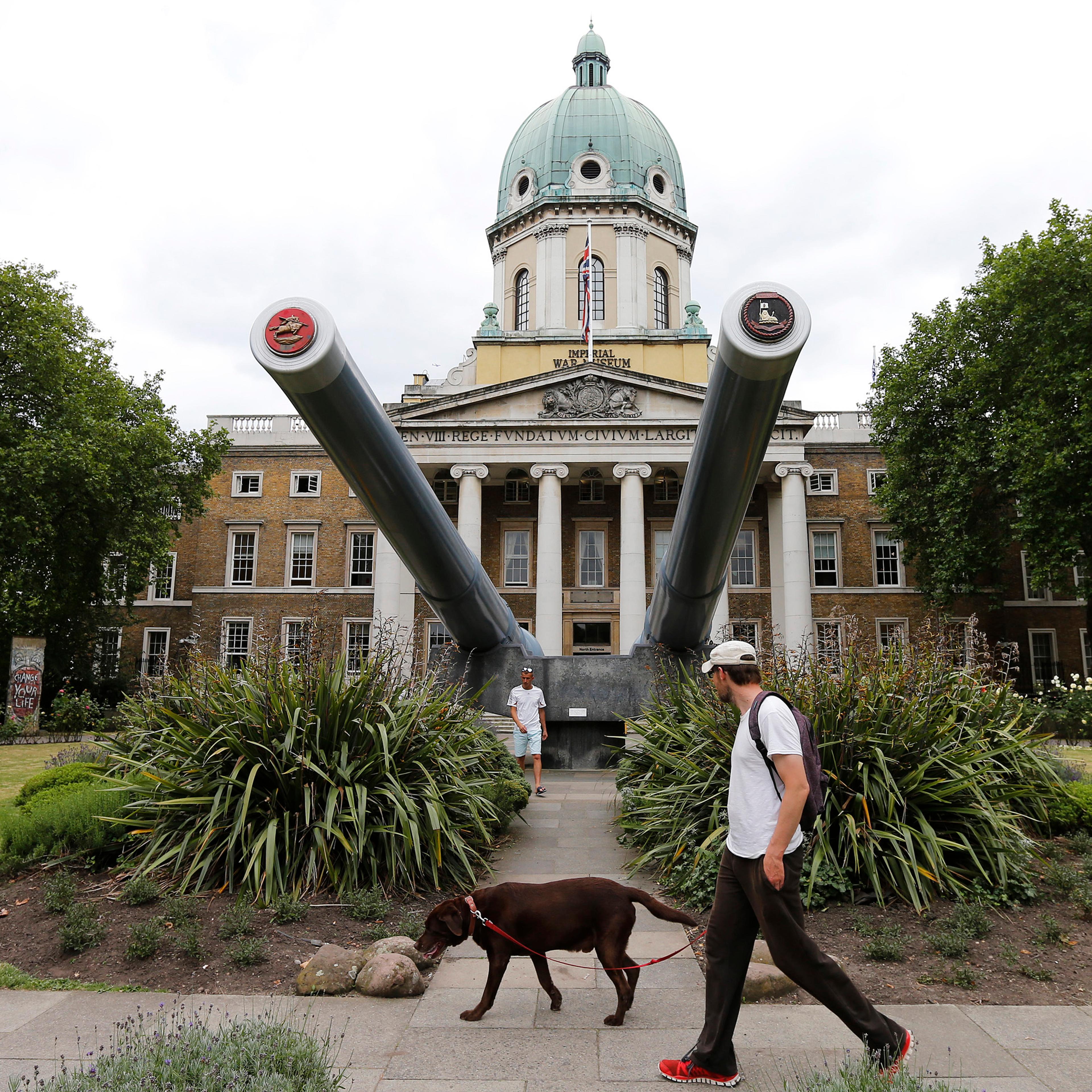 A man walks his dog past the newly re-opened Imperial War Museum in central London