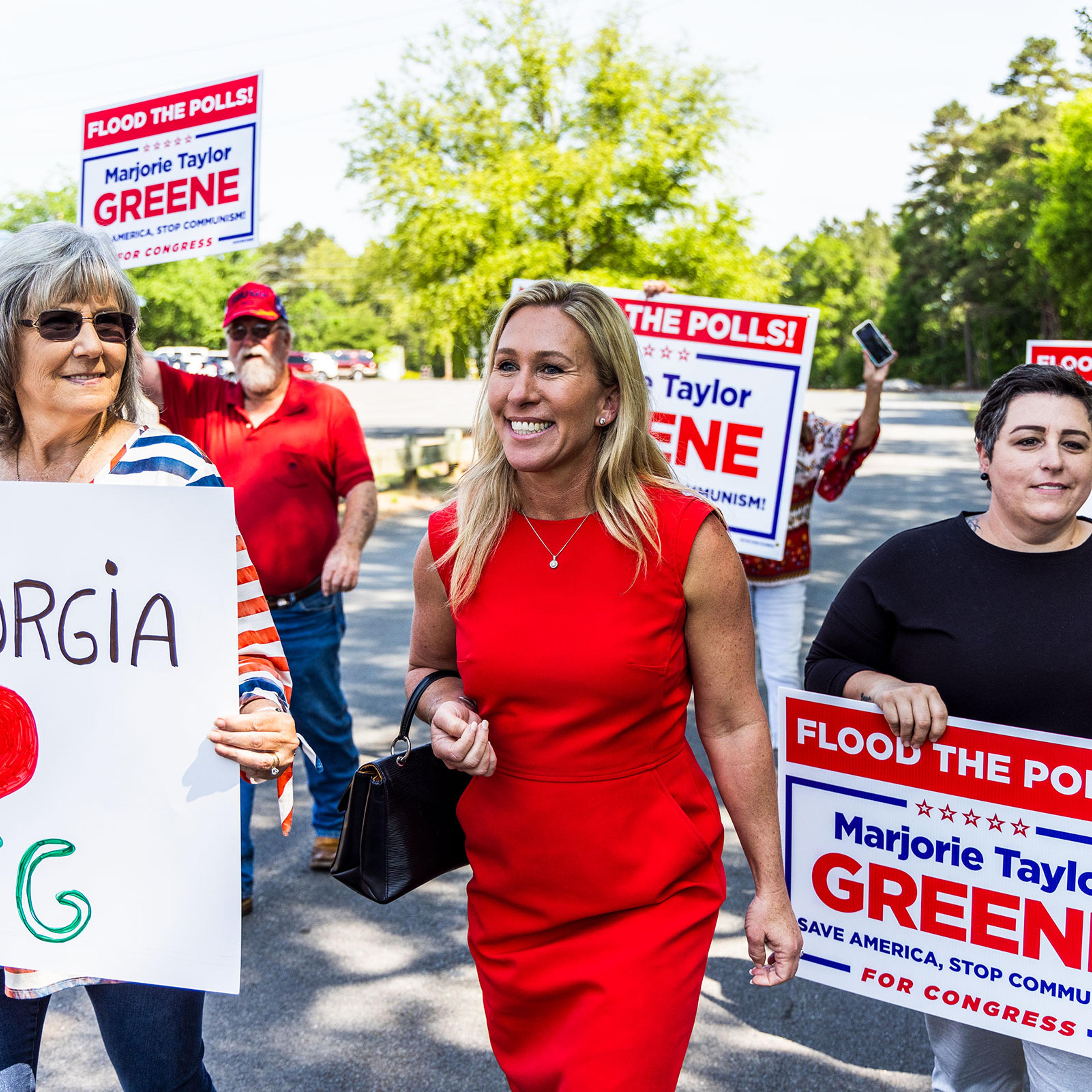 Marjorie Taylor Greene walks with supporters to cast her primary ballot in Rome, Ga., on the first day of early voting.