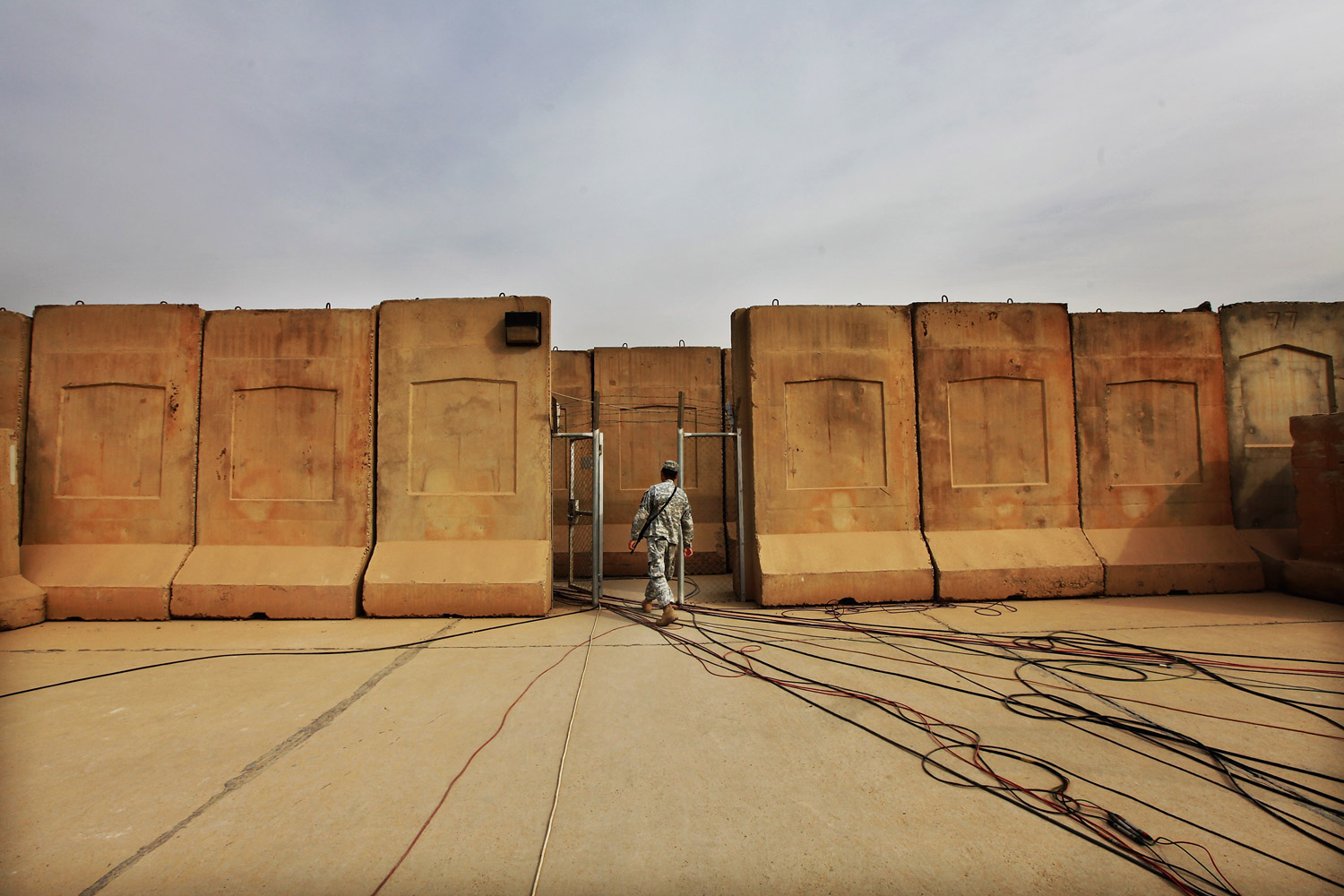 December 15, 2011. A U.S. military soldier walks past cables for media use before the start of a casing ceremony where the United States Forces - Iraq flag was retired, signifying the departure of United States troops from Iraq, at the former Sather Air Base in Baghdad, Iraq. United States forces are scheduled to entirely depart Iraq by December 31, there are currently around 4,000 troops remaining in Iraq. 