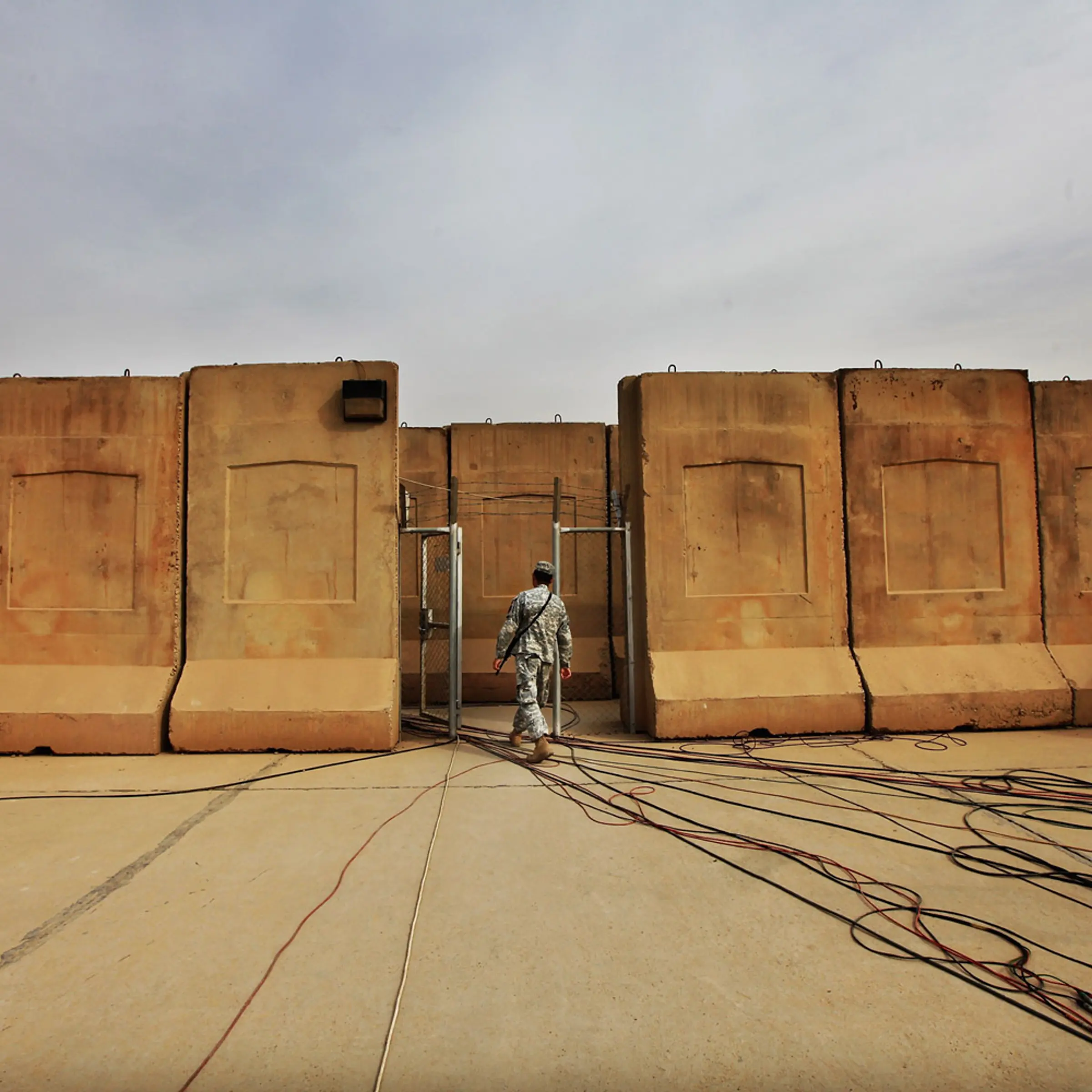 December 15, 2011. A U.S. military soldier walks past cables for media use before the start of a casing ceremony where the United States Forces - Iraq flag was retired, signifying the departure of United States troops from Iraq, at the former Sather Air Base in Baghdad, Iraq. United States forces are scheduled to entirely depart Iraq by December 31, there are currently around 4,000 troops remaining in Iraq.