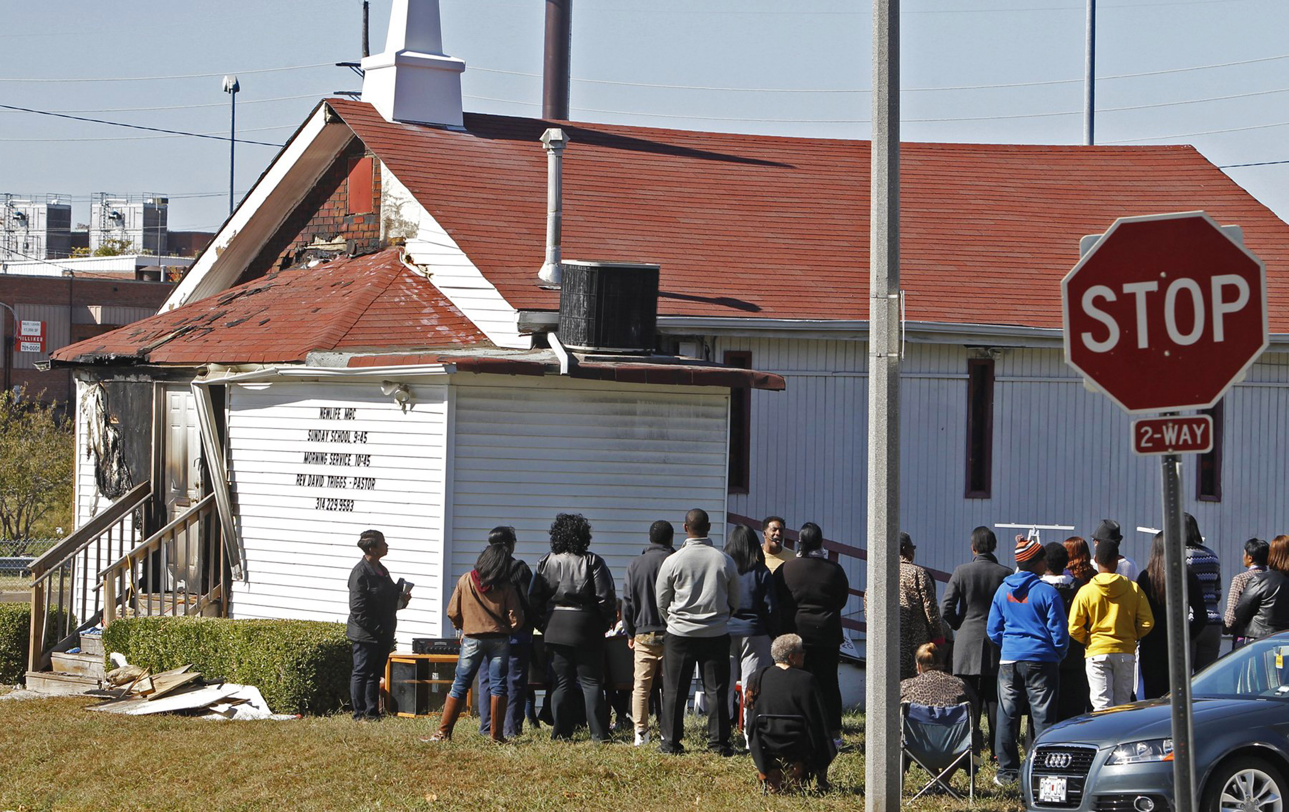 In this Sunday, Oct. 18, 2015 photo, an outdoor service is held following a fire at the New Life Missionary Baptist Church in St. Louis. Someone has been setting fire to predominantly black churches in the St. Louis area, and investigators are trying to 