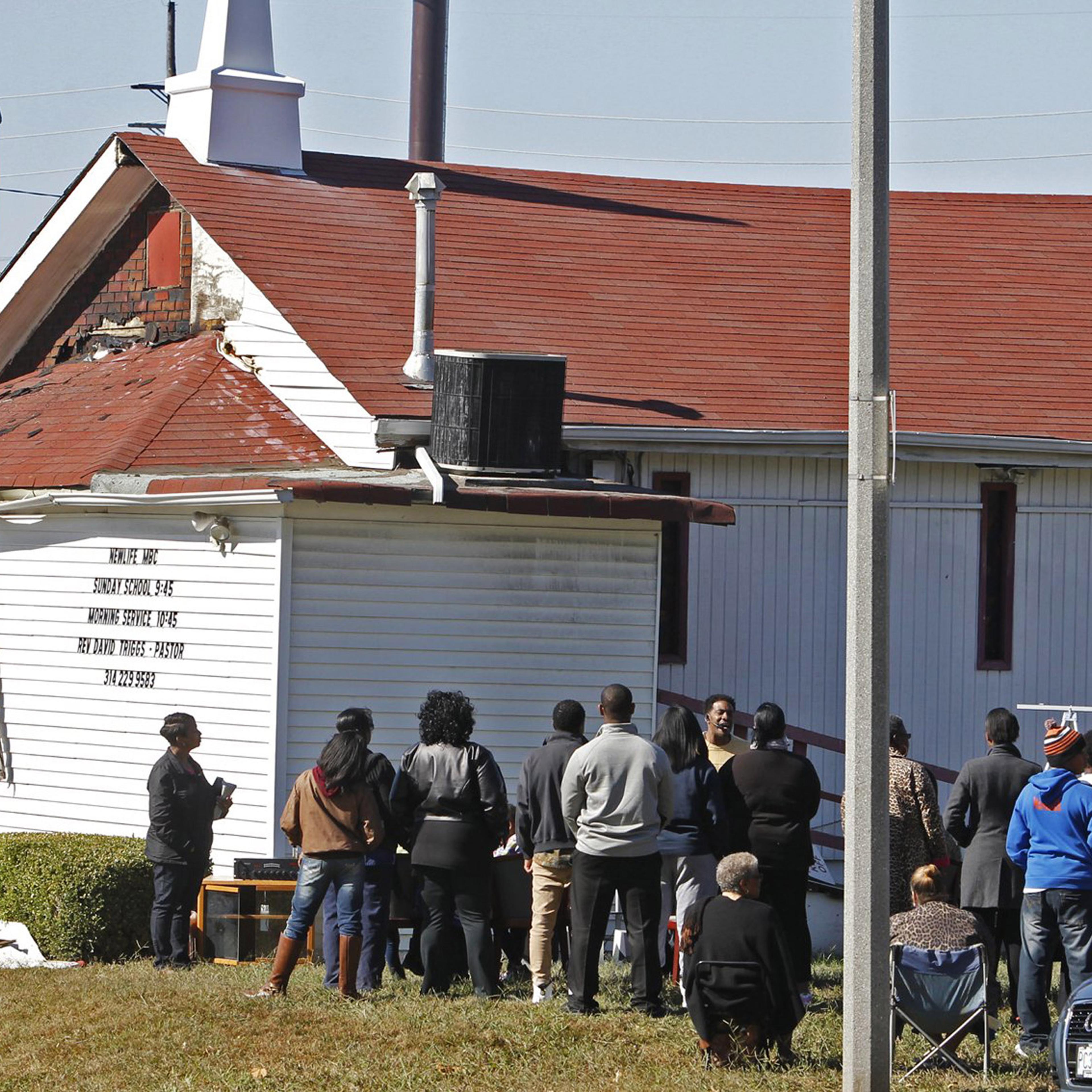 In this Sunday, Oct. 18, 2015 photo, an outdoor service is held following a fire at the New Life Missionary Baptist Church in St. Louis. Someone has been setting fire to predominantly black churches in the St. Louis area, and investigators are trying to