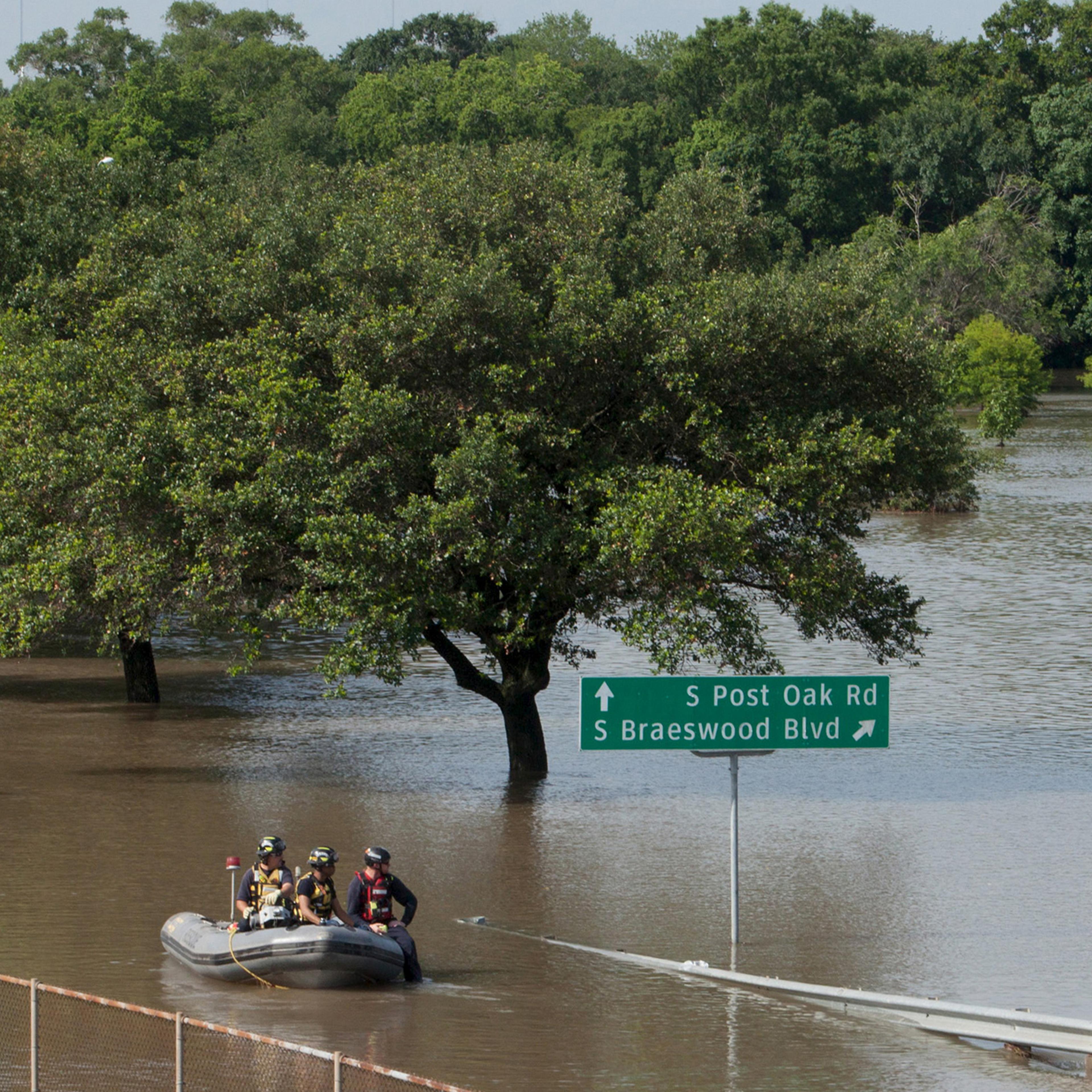 Rescue personnel search the floodwaters along Brays Bayou in southwest Houston, Texas