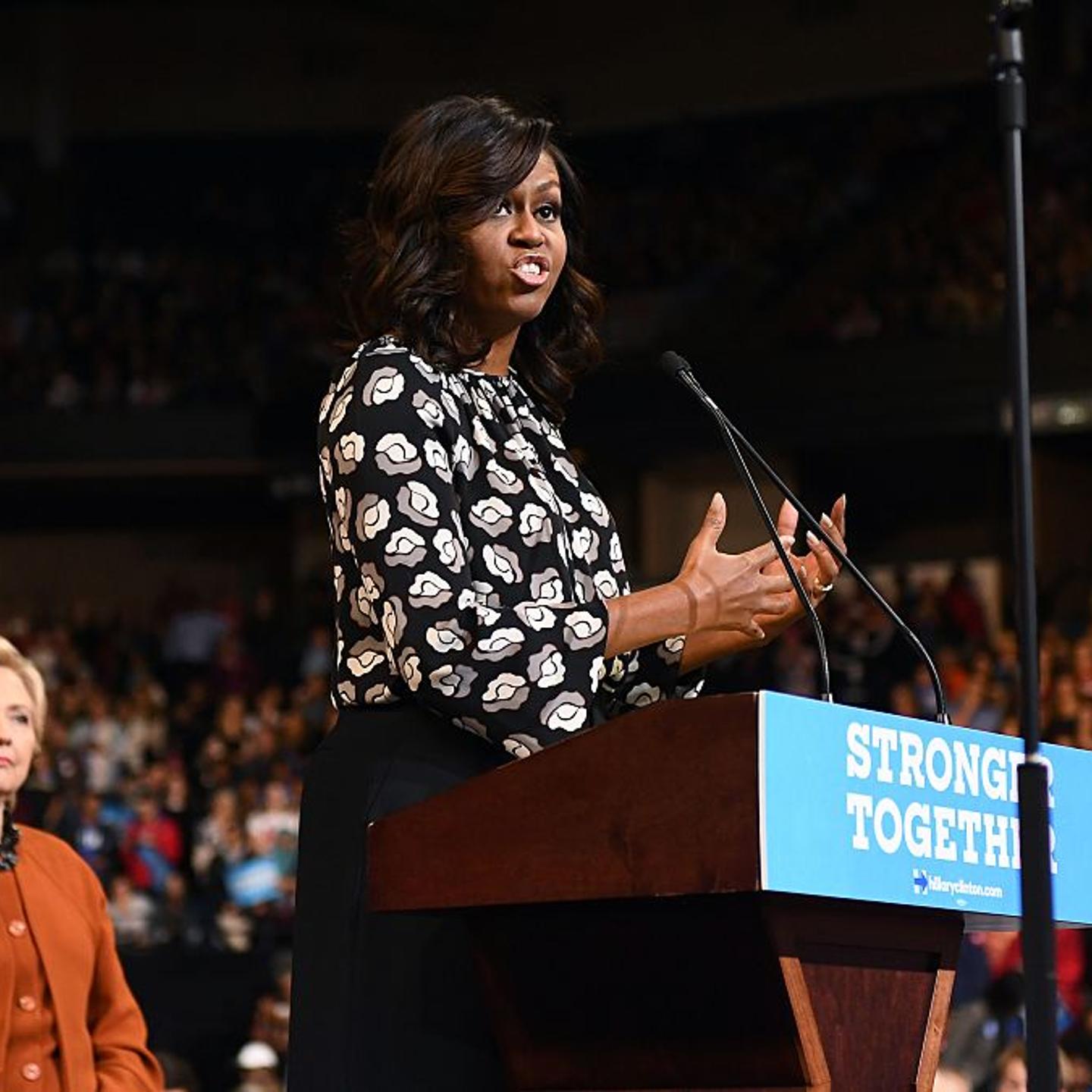 First Lady Michelle Obama speaks as Democratic presidential nominee Hillary Clinton listens during a campaign rally in Winston-Salem, North Carolina on October 27, 2016.