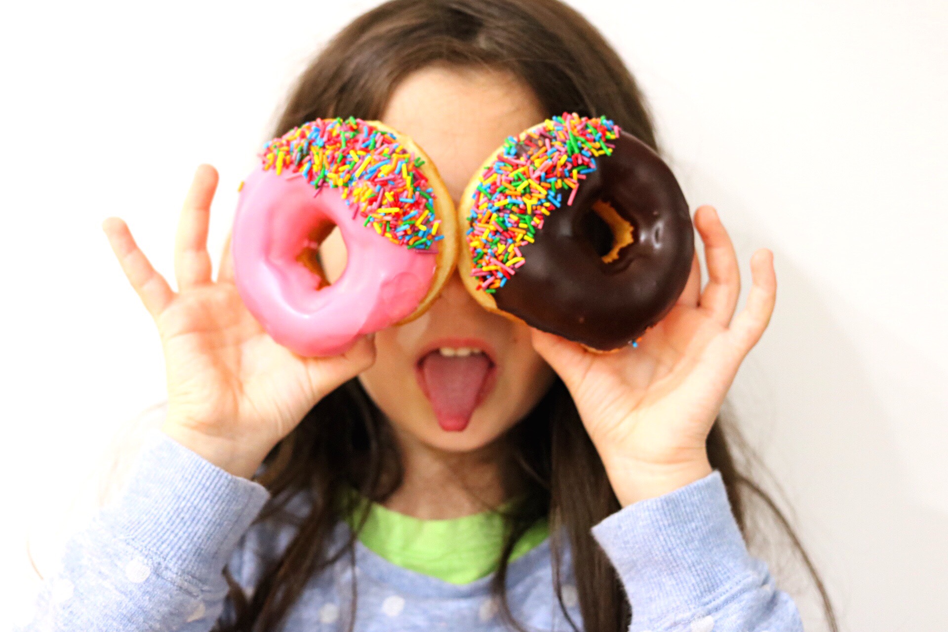 Girl Holding Donuts Over Her Eyes