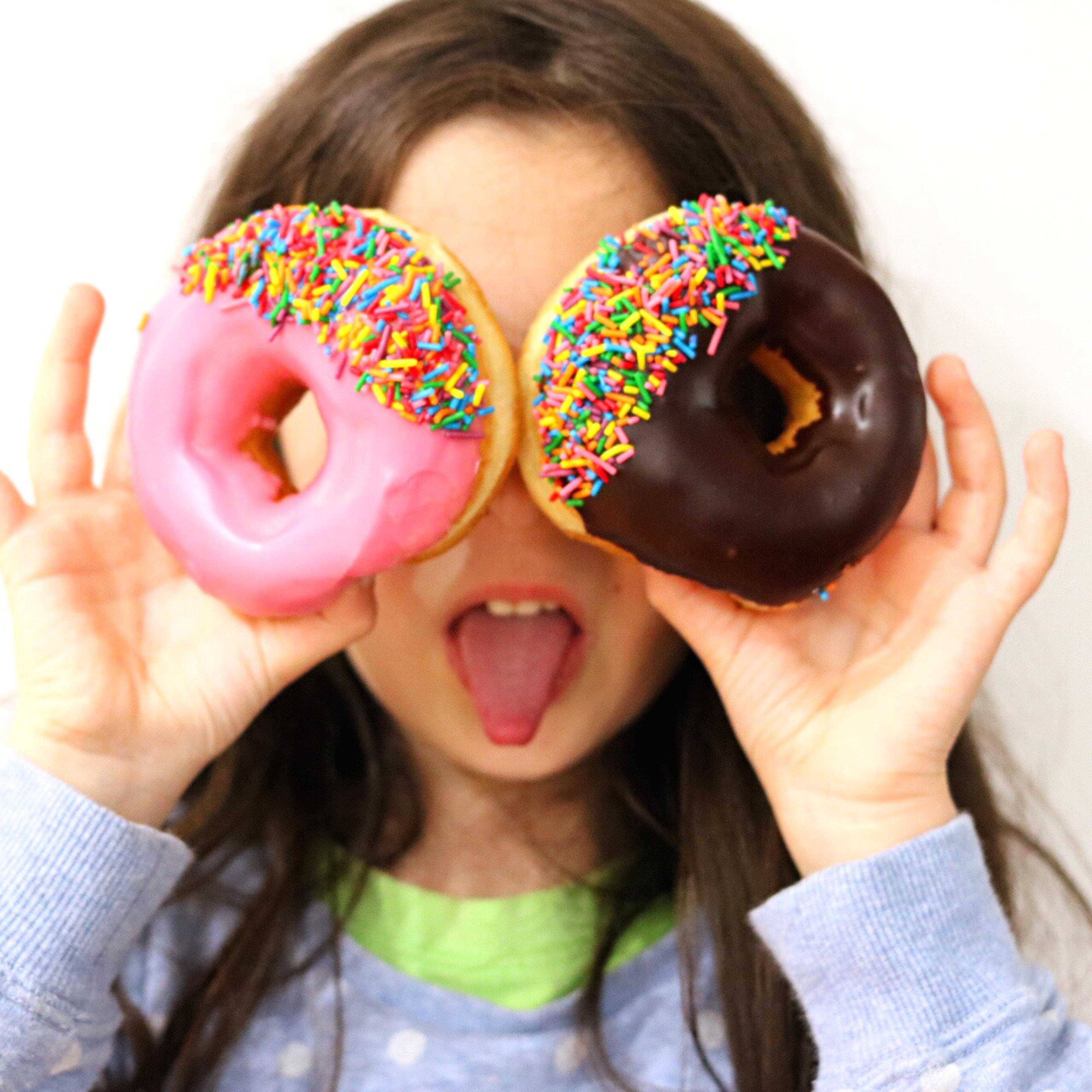 Girl Holding Donuts Over Her Eyes
