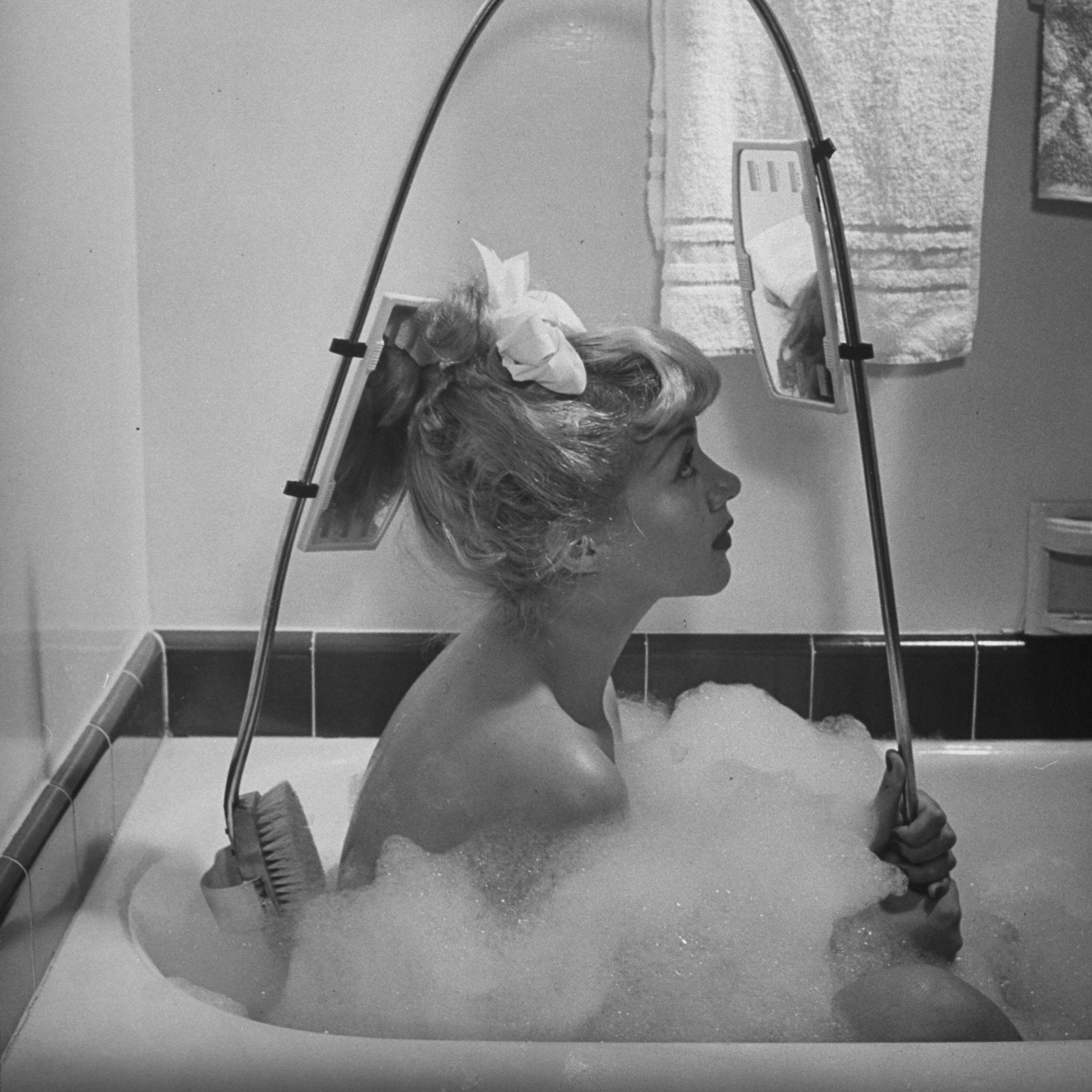 New back brush lets bather see just what she is up to.