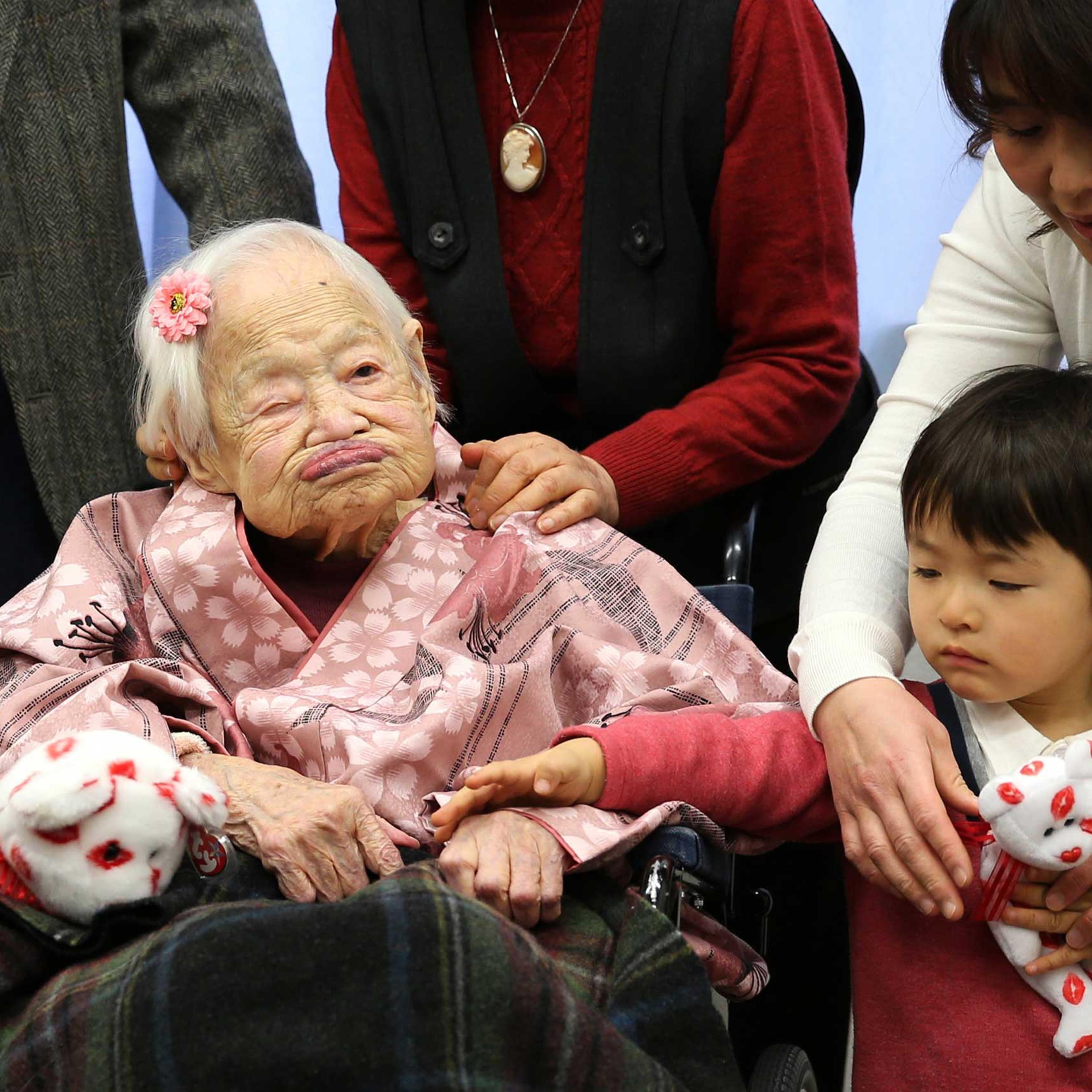 Misao Okawa, the world's oldest Japanese woman poses for a photo with her great-grandchild Himaki and grandchild Takako Okawa on her 117th birthday celebration at Kurenai Nursing Home on March 4, 2015 in Osaka, Japan.