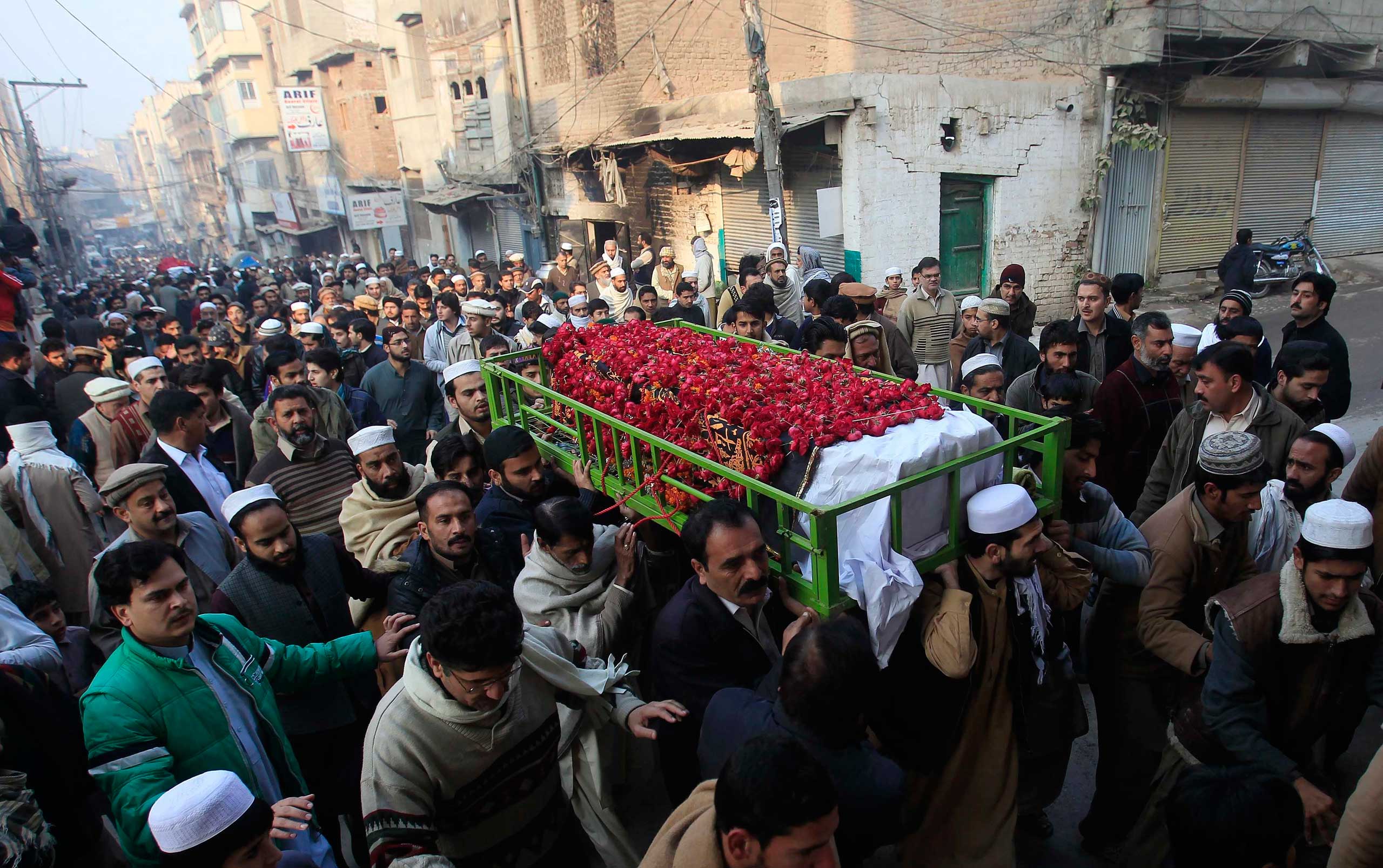 People carry the coffin of a male student who was killed in Tuesday's attack on the Army Public School, which was attacked by Taliban gunmen, during his funeral in Peshawar, Dec. 17, 2014.