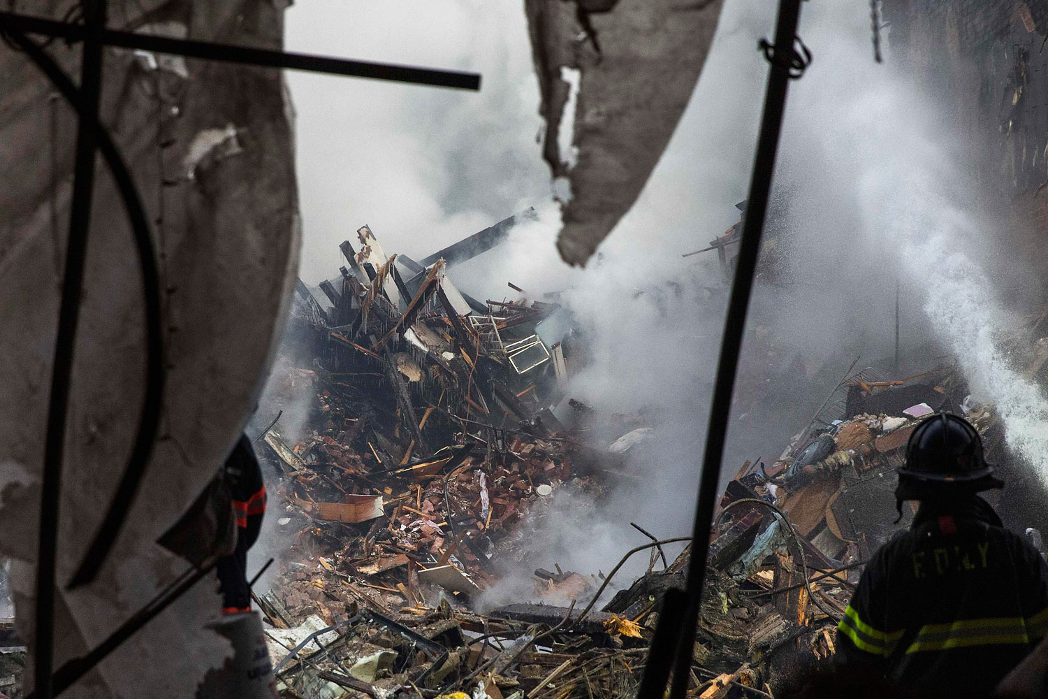 New York City emergency responders search through the rubble at the site of a building explosion in the Harlem section of New York, March 13, 2014.
