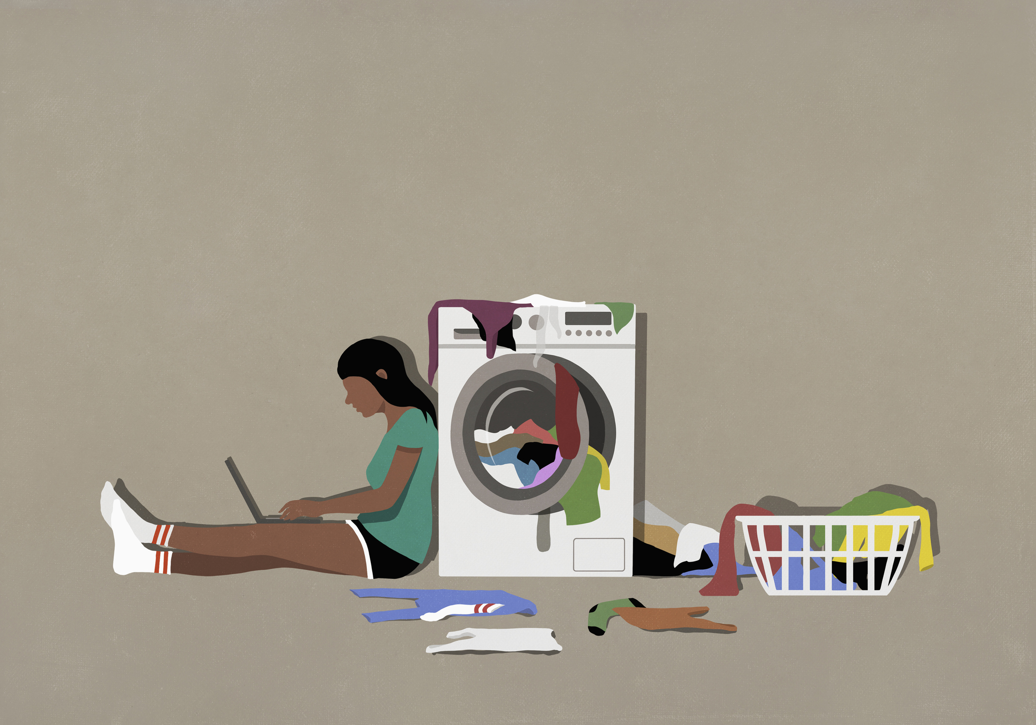 Girl using laptop and doing laundry at clothes dryer