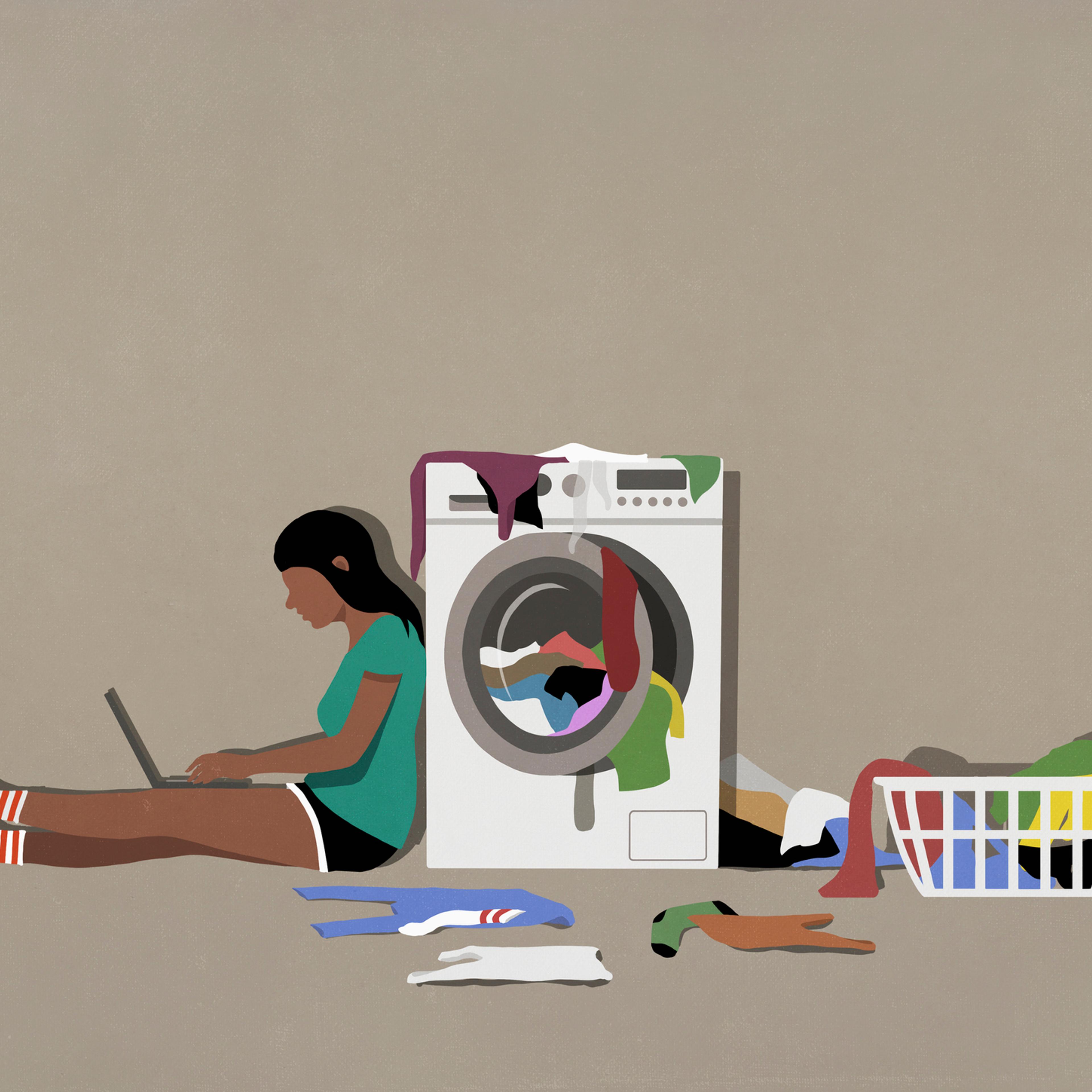 Girl using laptop and doing laundry at clothes dryer