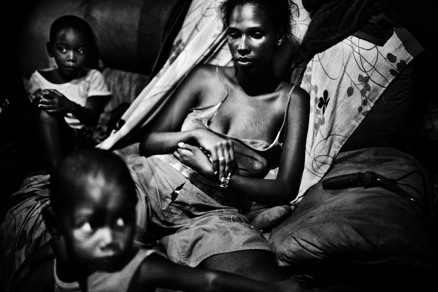 Sebastian Liste, The Brazilian Far West<br><br>Salvador de Bahia, Brazil. Melanie, 22, with her two sons in a small shack in an abandoned chocolate factory. In spite of the extreme conditions, this factory in ruins has become a home for her family.