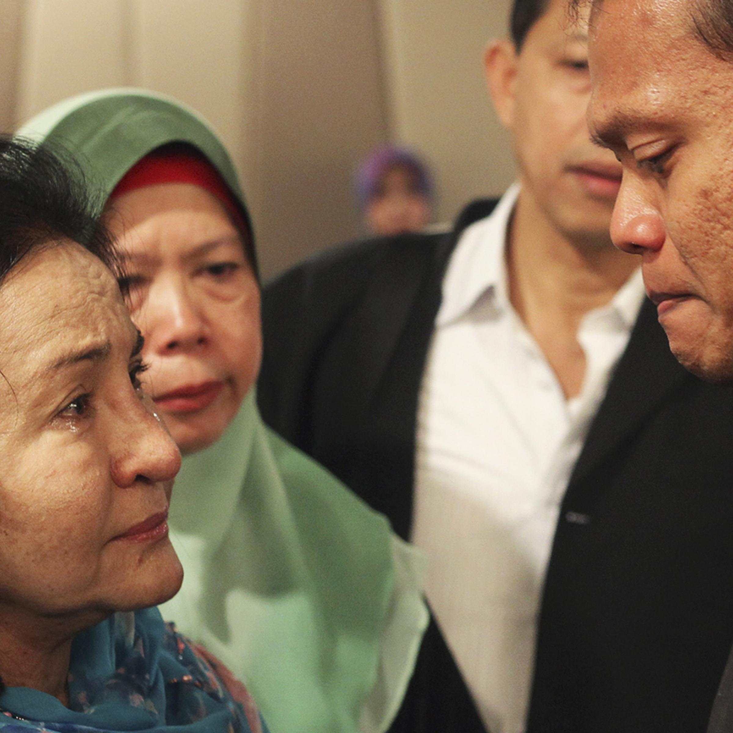 Rosmah Mansor, left, wife of Malaysian Prime Minister Najib Razak, cries with family members of passengers on the missing Malaysia Airlines flight MH370, at a hotel in Putrajaya March 9, 2014.