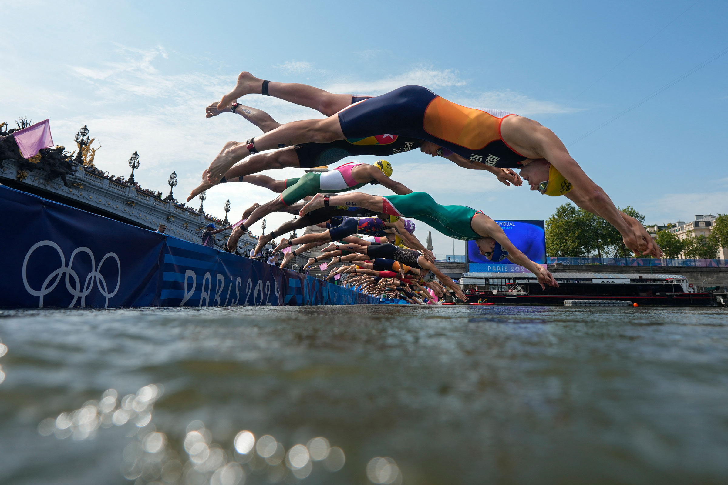 Athletes dive into the Seine river to start the swimming stage of the men’s individual triathlon at the Paris 2024 Olympic Games on July 31, 2024.