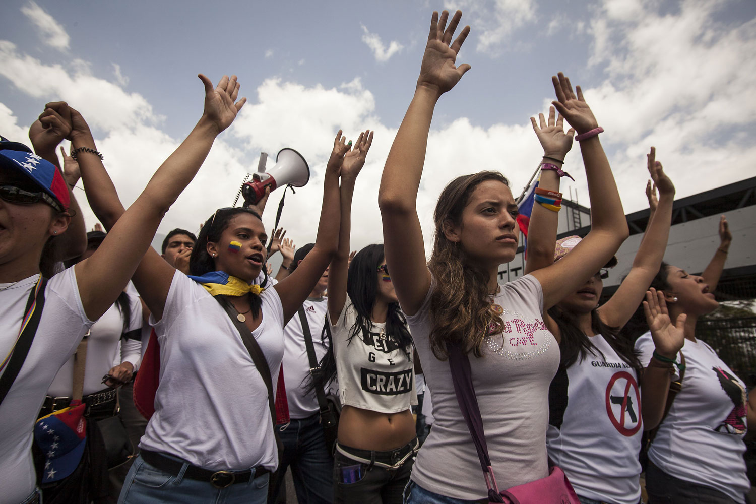 Protesters raise their hands in a sign of peace after the Bolivarian National Guard cut the march in two parts, not allowing part of the march to continue, Caracas, March 4, 2013.