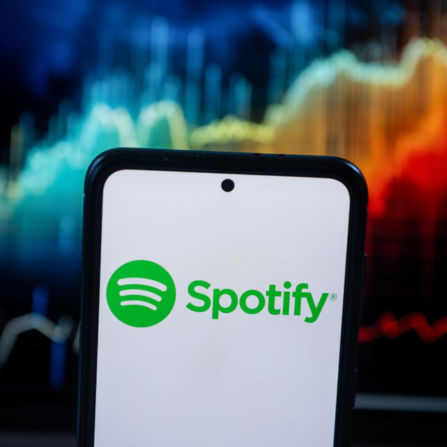 In this photo illustration a Spotify logo seen displayed on