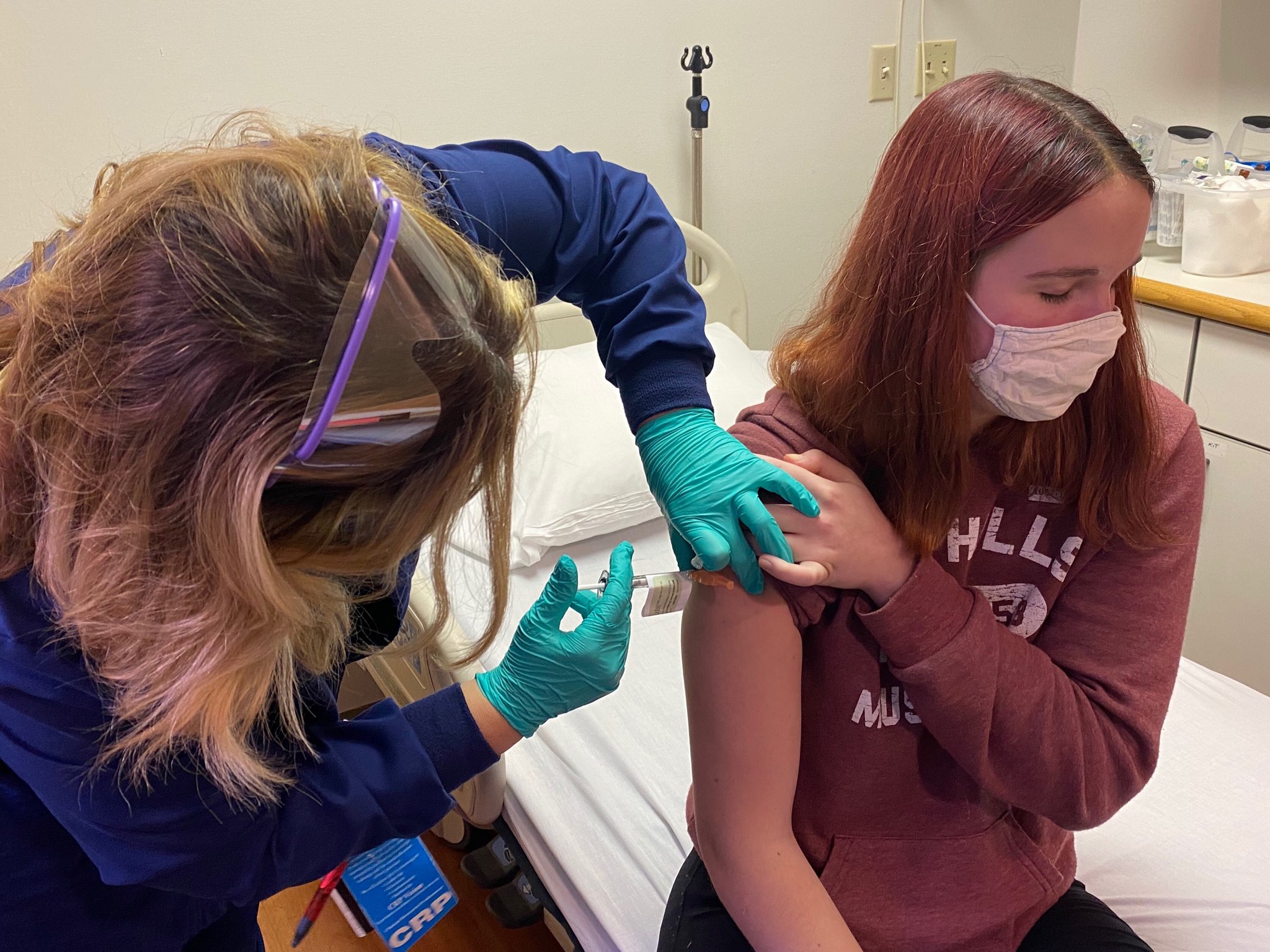 Clinical research coordinator Tammy Lewis-McCauley administers Katelyn Evans, 16, an injection as part of the hospital’s clinical trial of the Pfizer COVID-19 vaccine.