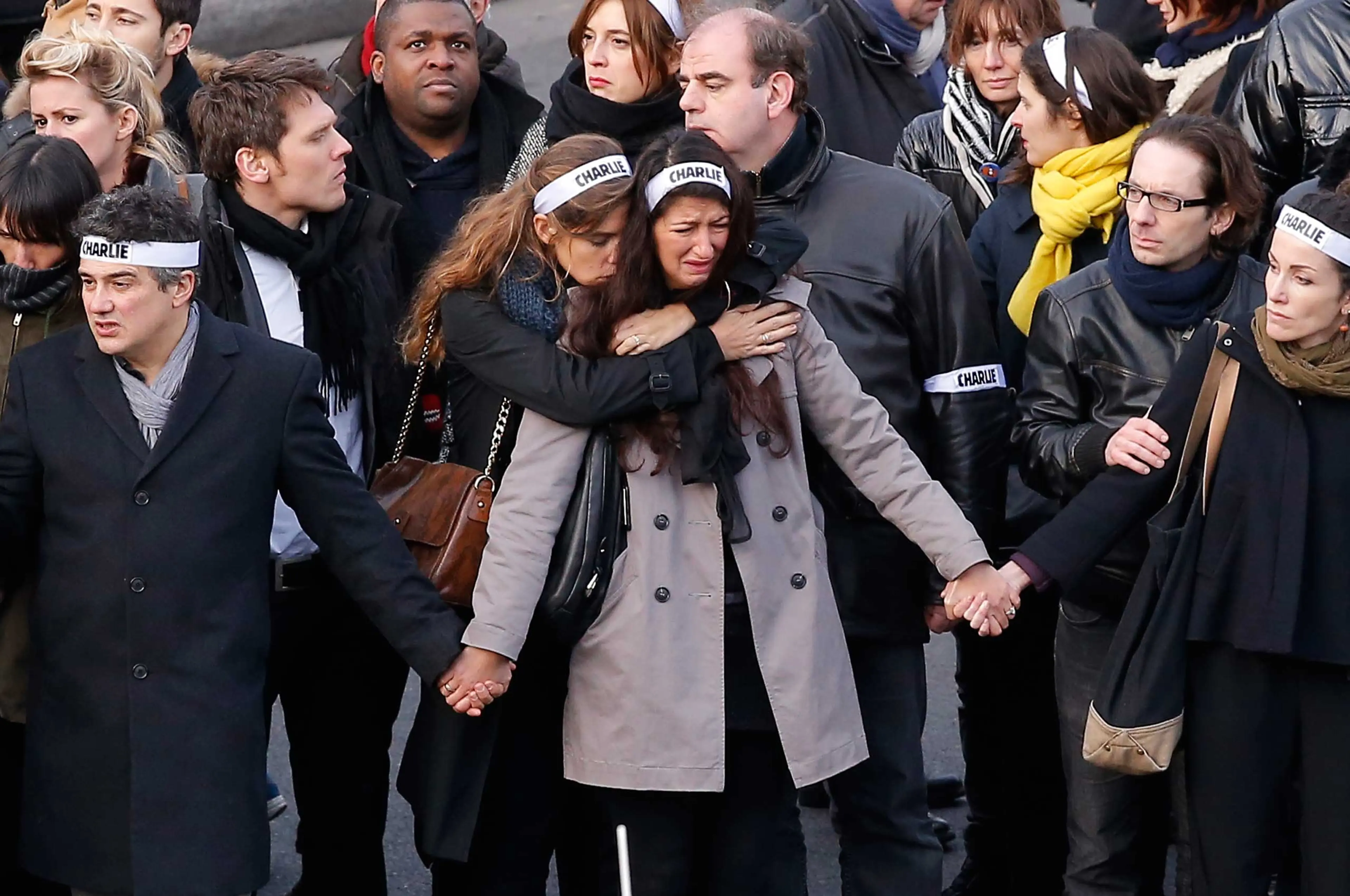 Families and relatives walk and hold banners reading 'Charlie' during a march to honor victims of the terrorist attacks and show unity, in Paris, Jan.11, 2015.