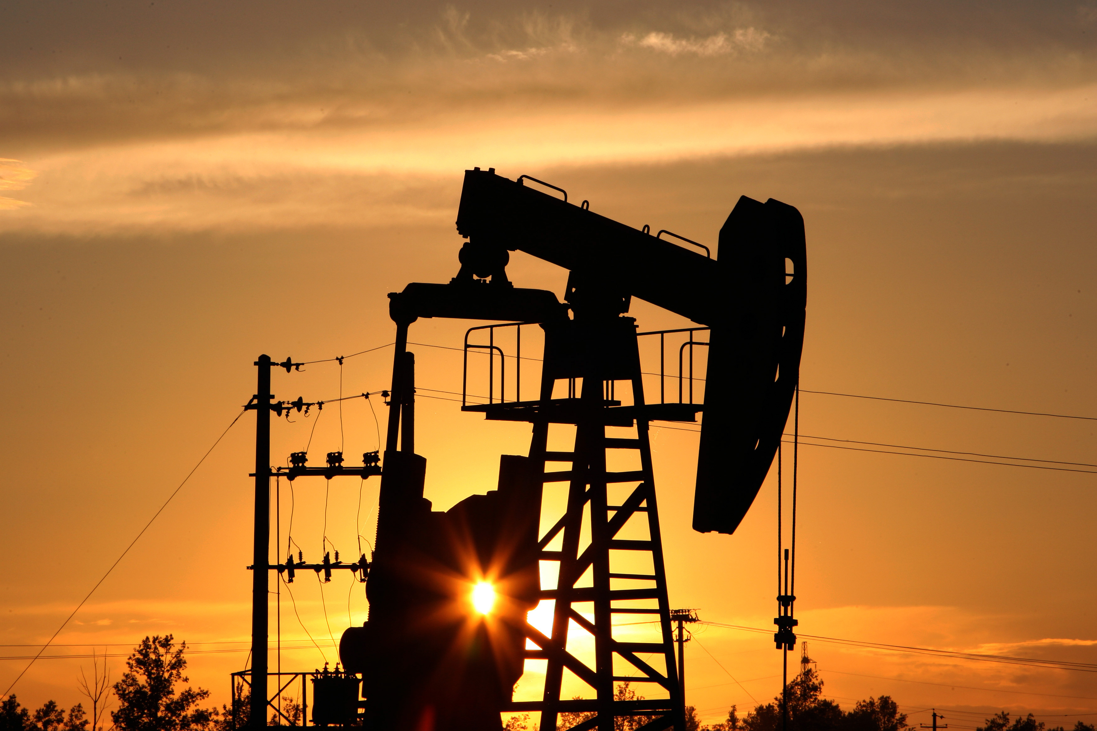 A CNPC 'nodding donkey' oil pump is seen at sunset in an oilfield outside Daqing, Heilongjiang province, China.