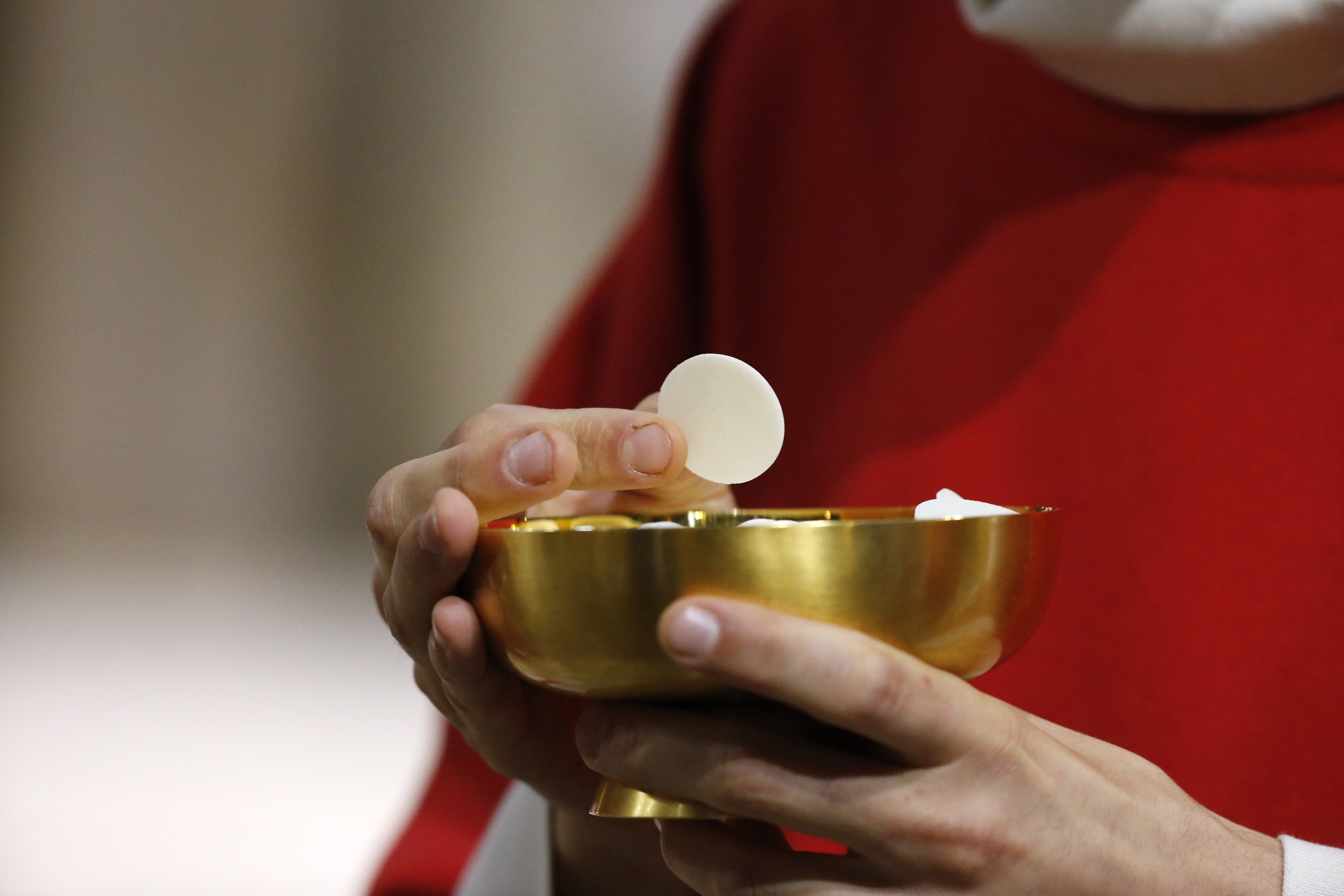 Catholic priest giving holy communion.