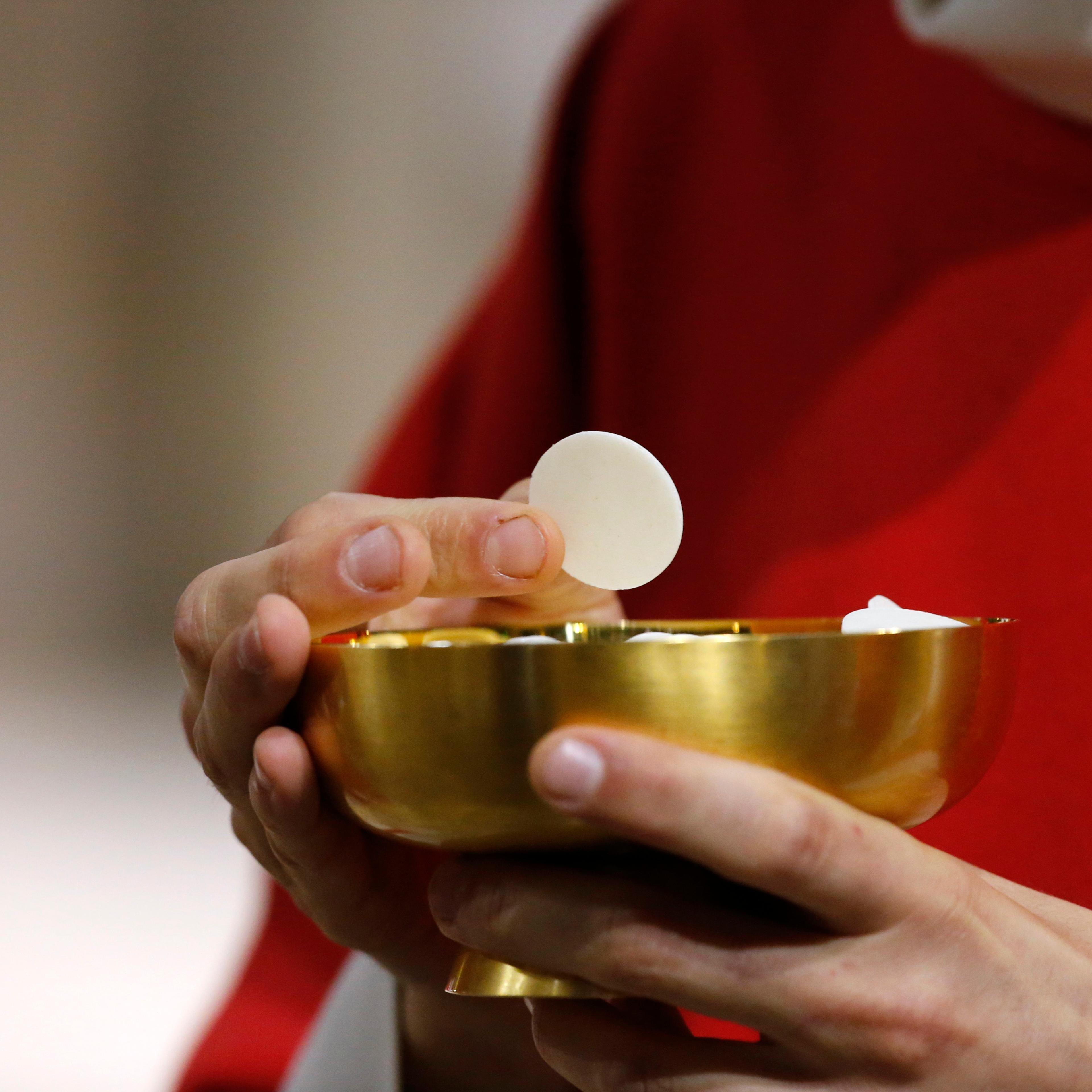 Catholic priest giving holy communion.