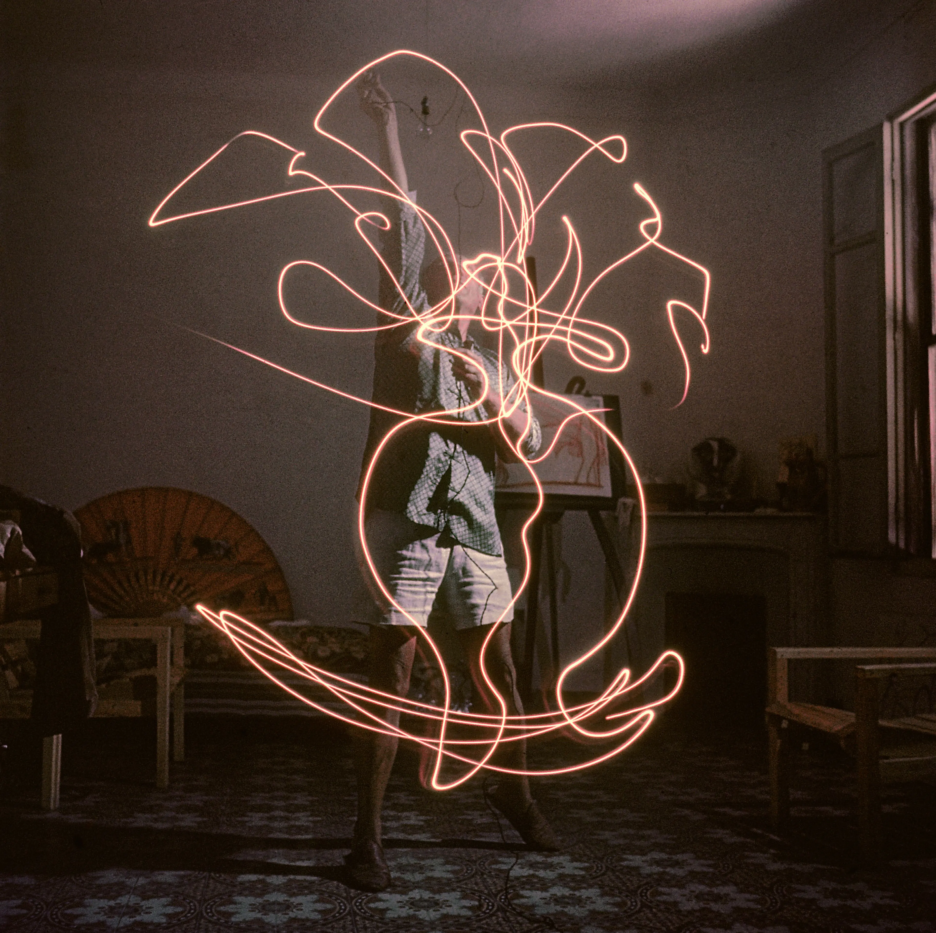 Pablo Picasso "draws" a vase of flowers with light, 1949.