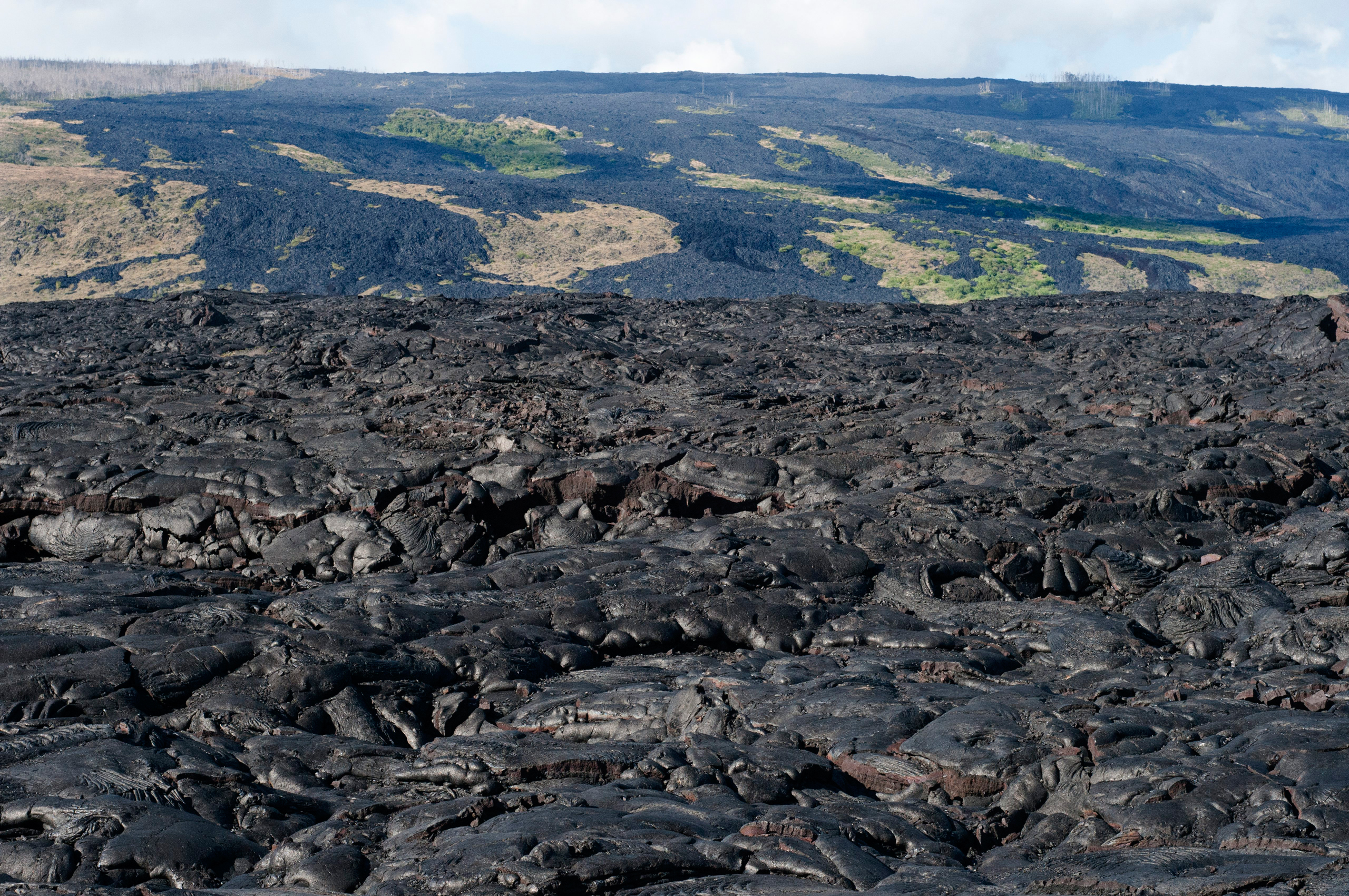 Black lava mountains near the coast and highway Chain of Crater Road. Hawai'i Volcanoes National Park. Big Island. Hawaii. Lava fields and the pacific ocean with a fish eye lens, Volcano National Park. Recent lava flow, pahoehoe type lava. Hawai?i Volcan