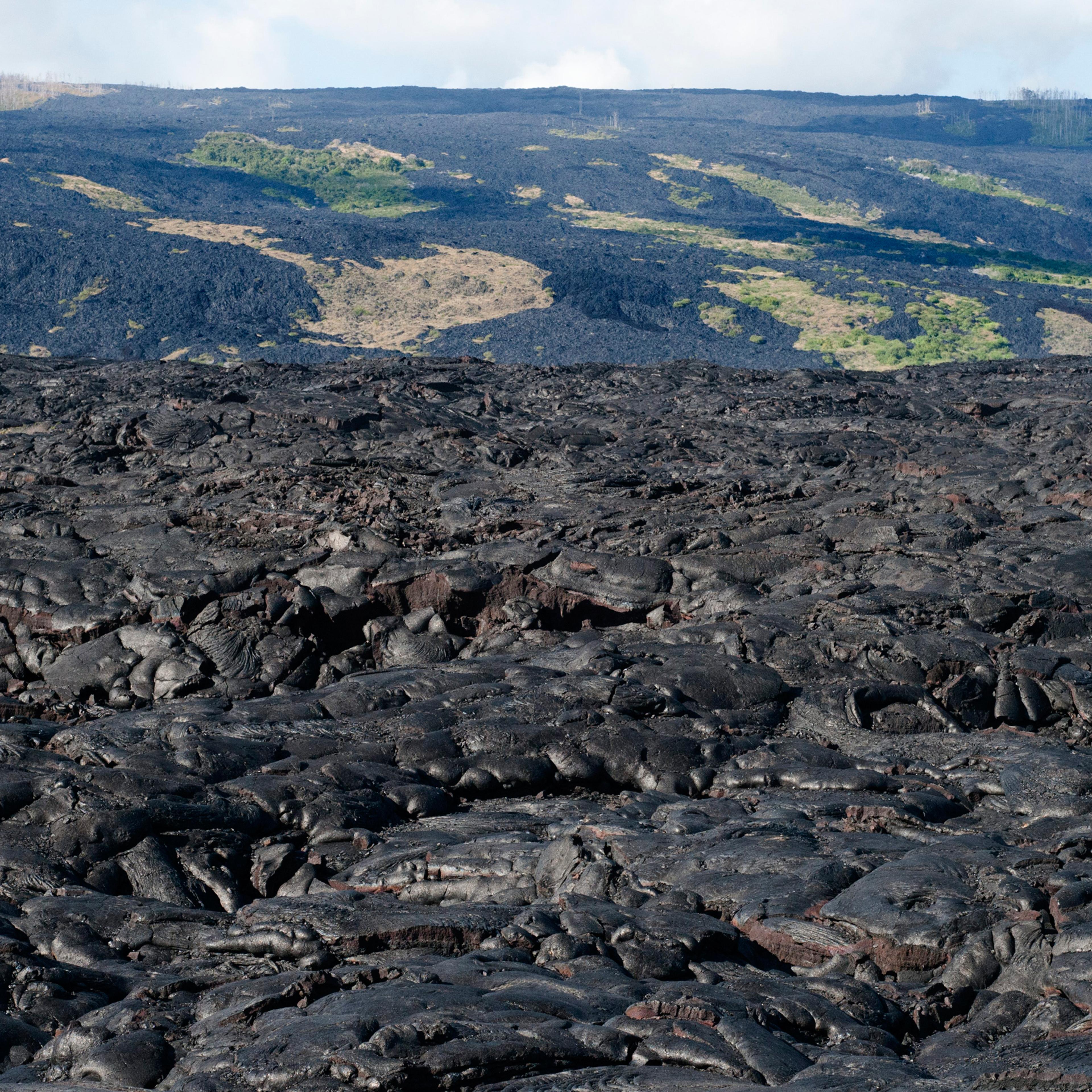 Black lava mountains near the coast and highway Chain of Crater Road. Hawai'i Volcanoes National Park. Big Island. Hawaii. Lava fields and the pacific ocean with a fish eye lens, Volcano National Park. Recent lava flow, pahoehoe type lava. Hawai?i Volcan