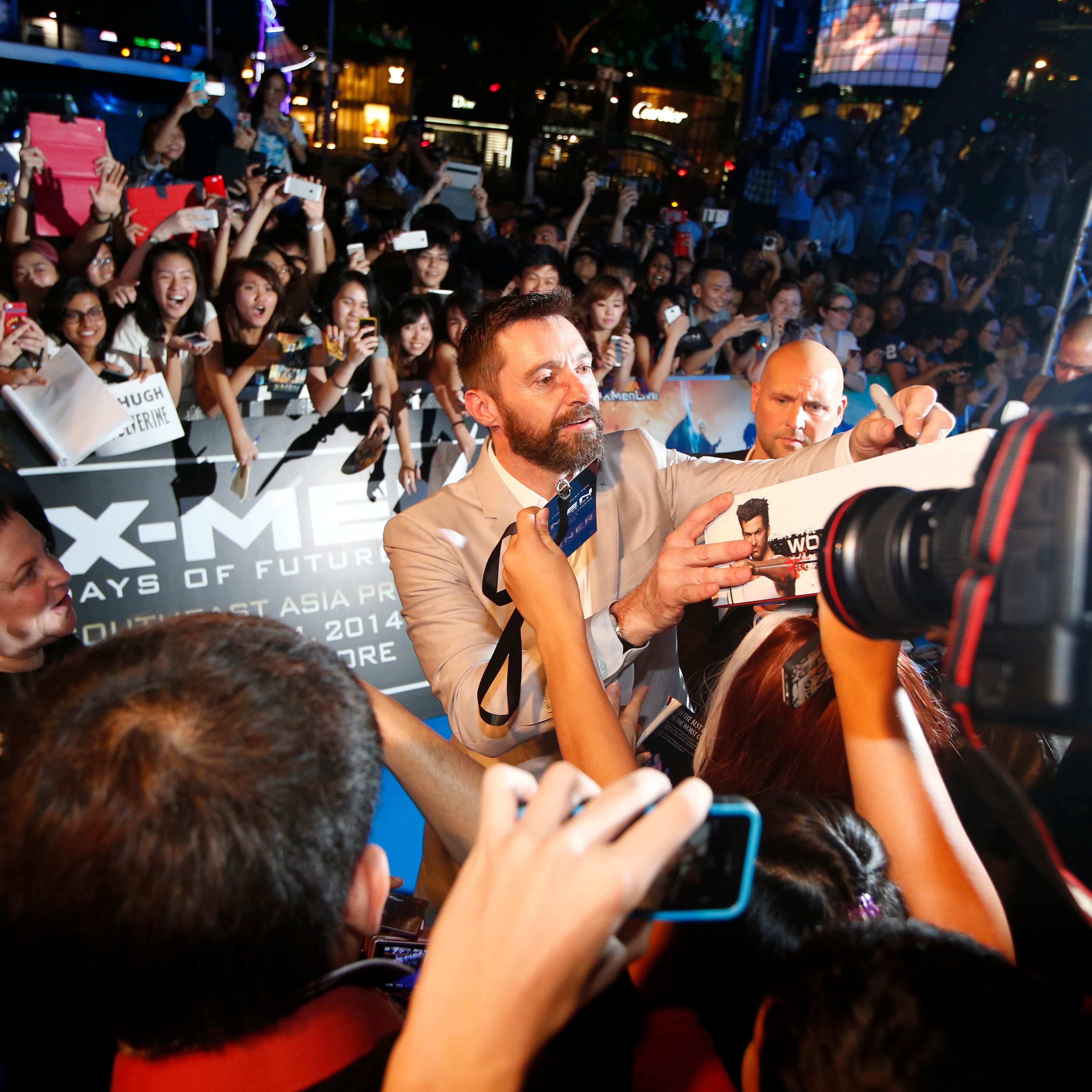 Cast member Hugh Jackman signs autographs for fans at the South East Asia premiere of X-Men: Days Of Future Past in Singapore