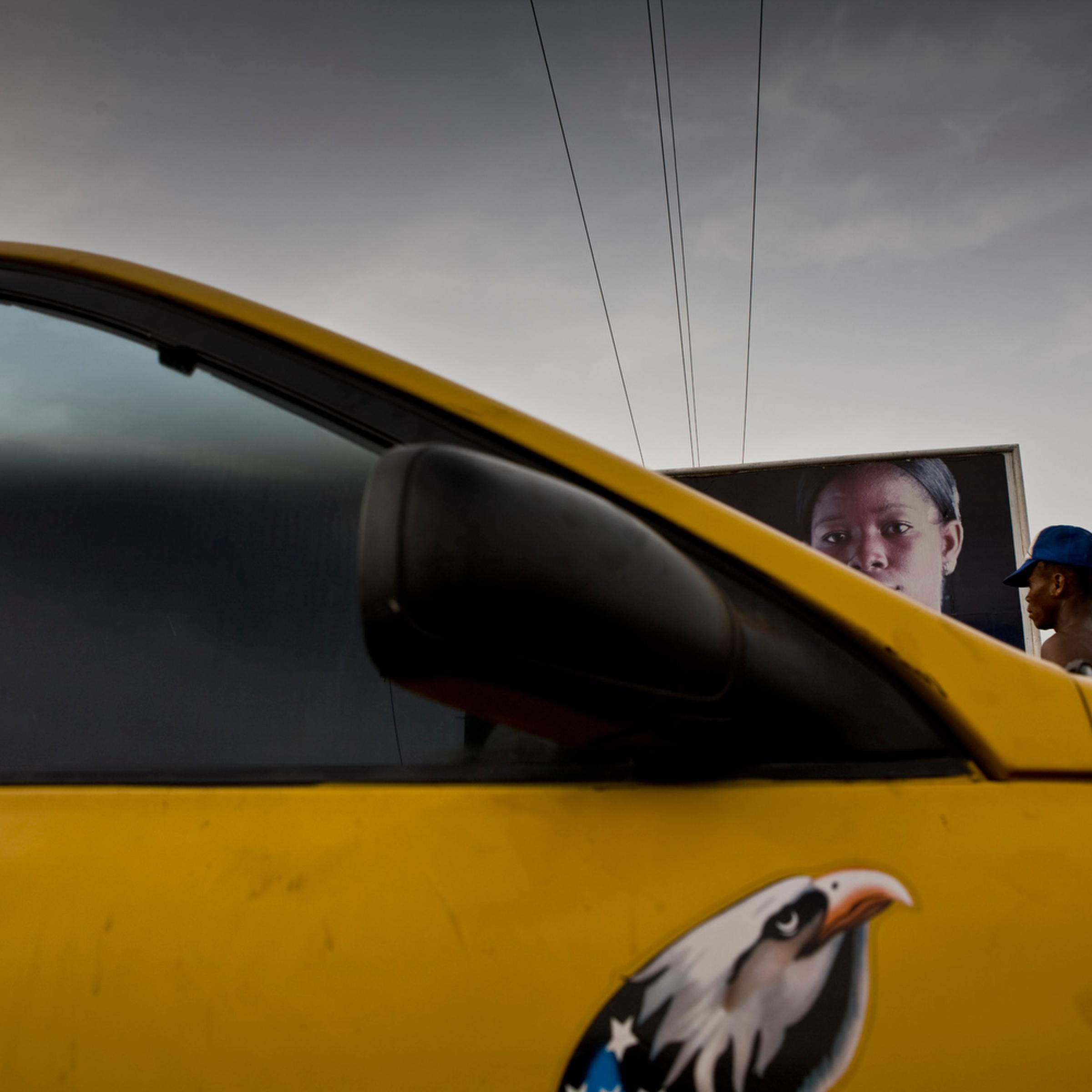 A taxi drives by an antirape billboard in Monrovia, the capital of Liberia.