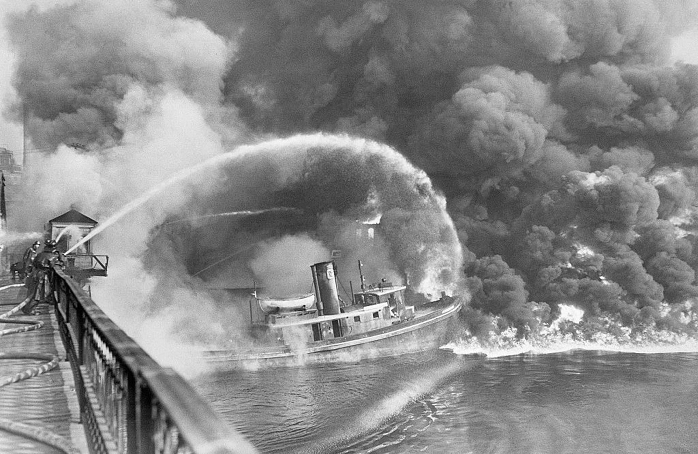 Firemen trying to put out a 1952 blaze on the Cuyahoga River.