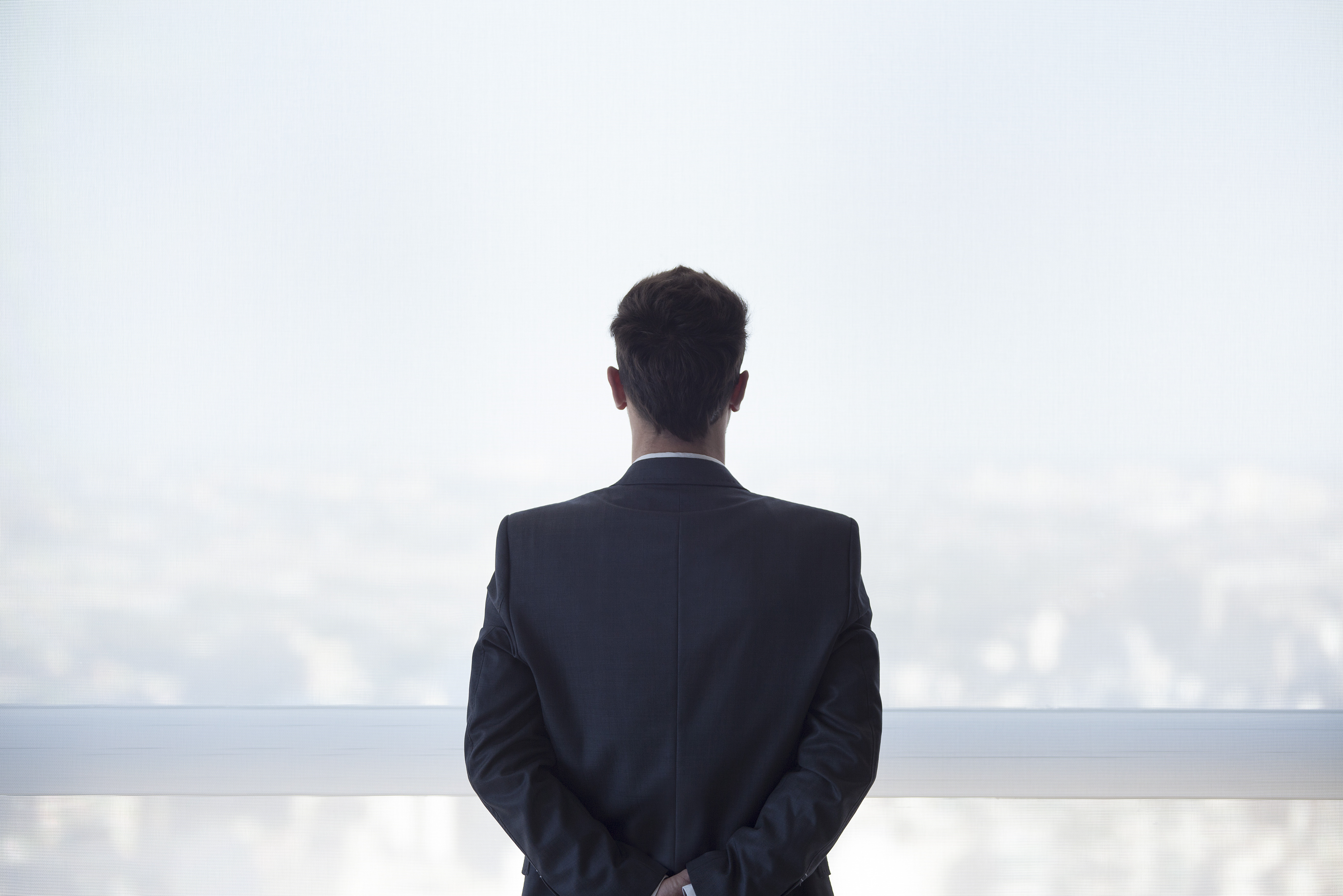 businessman-standing-looking-out-window