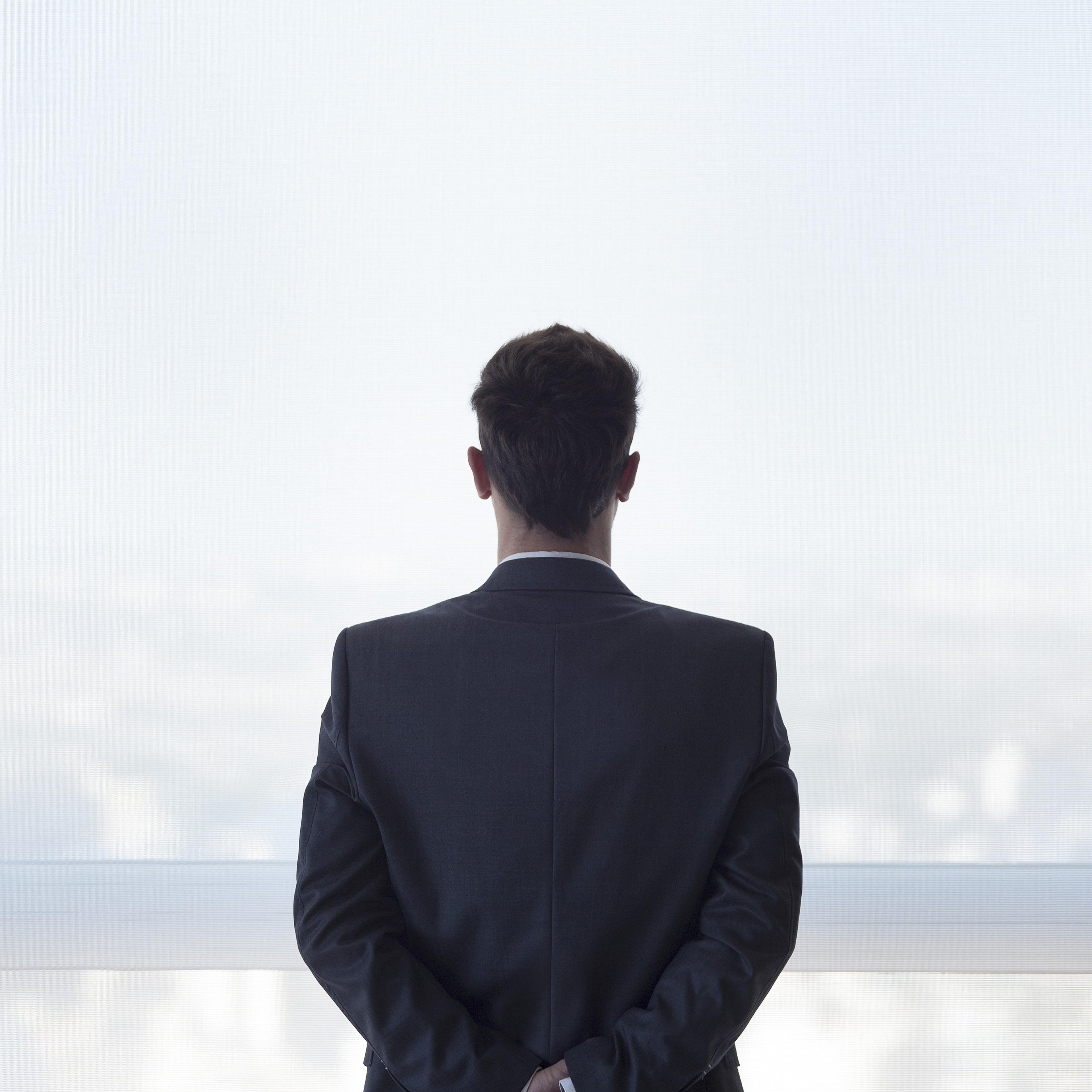businessman-standing-looking-out-window