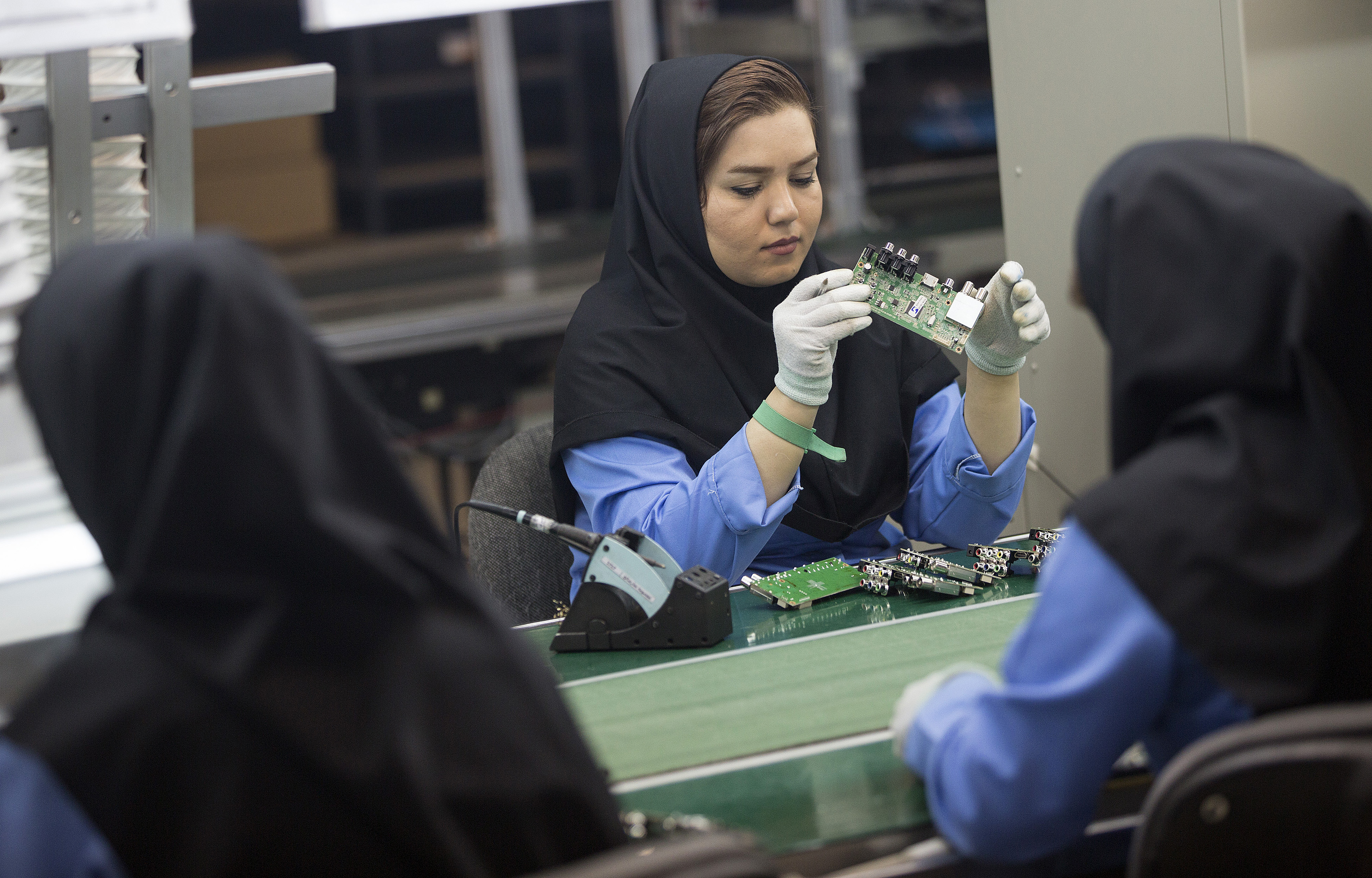 Female employees work on the assembly of electronic circuit boards at the Maadiran Group electronics distribution and manufacturing plant in Hashtgerd, Iran, on Tuesday, Sept. 1, 2015. 