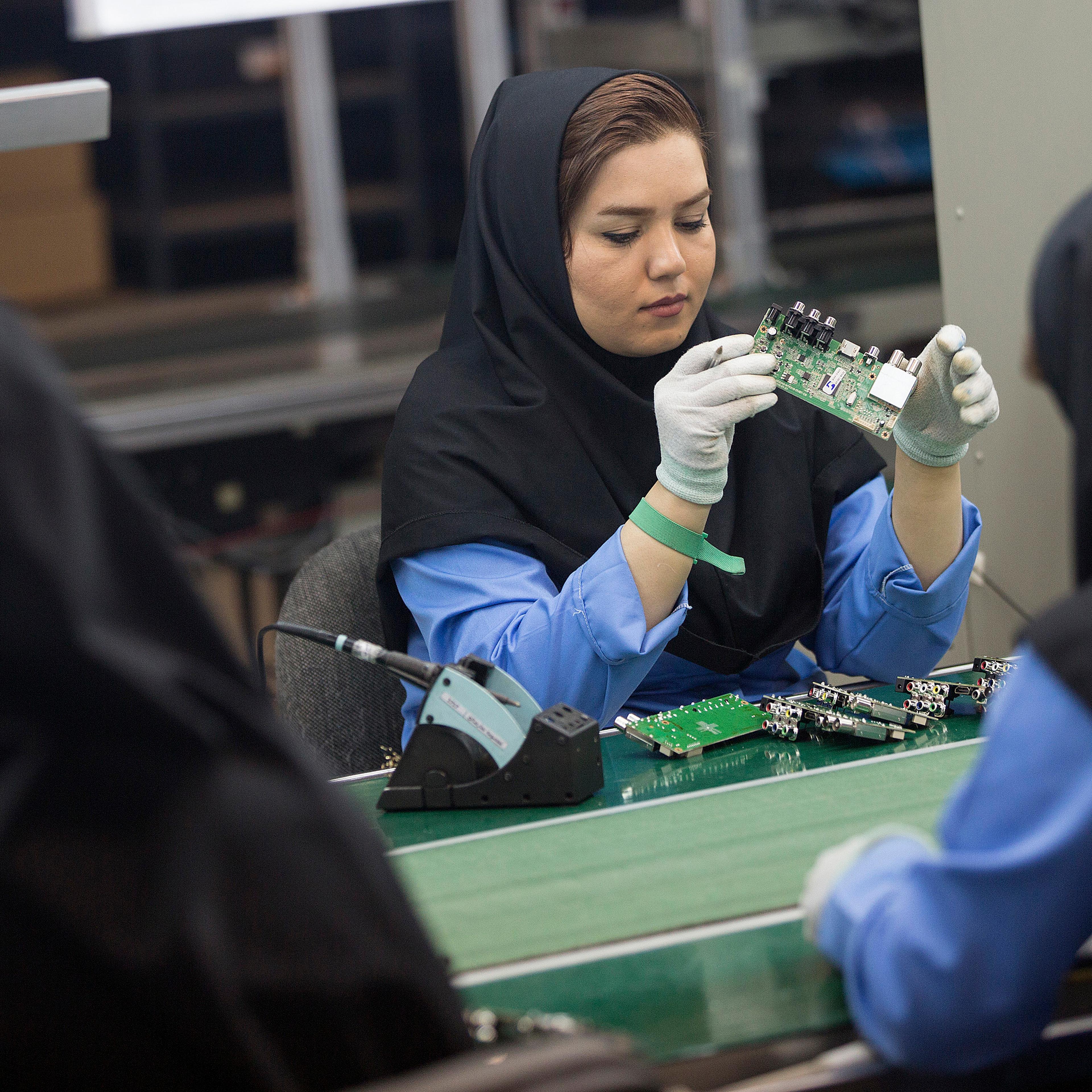 Female employees work on the assembly of electronic circuit boards at the Maadiran Group electronics distribution and manufacturing plant in Hashtgerd, Iran, on Tuesday, Sept. 1, 2015.