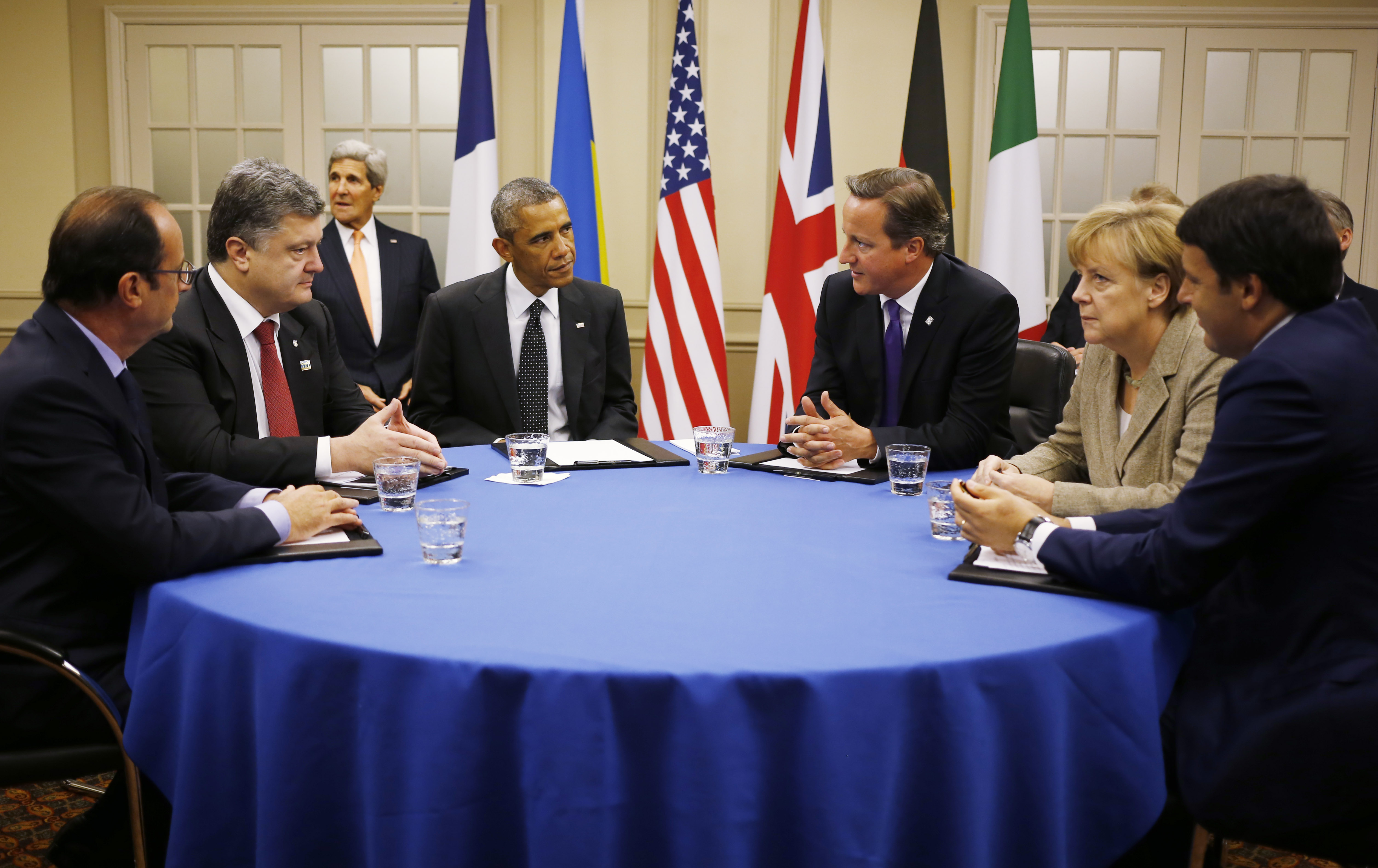 U.S. President Barack Obama is seated at a table with, from left to right: France's President Francois Hollande; Ukraine President Petro Poroshenko; British Prime Minister David Cameron; German Chancellor Angela Merkel; and Italian Prime Minister Matteo 