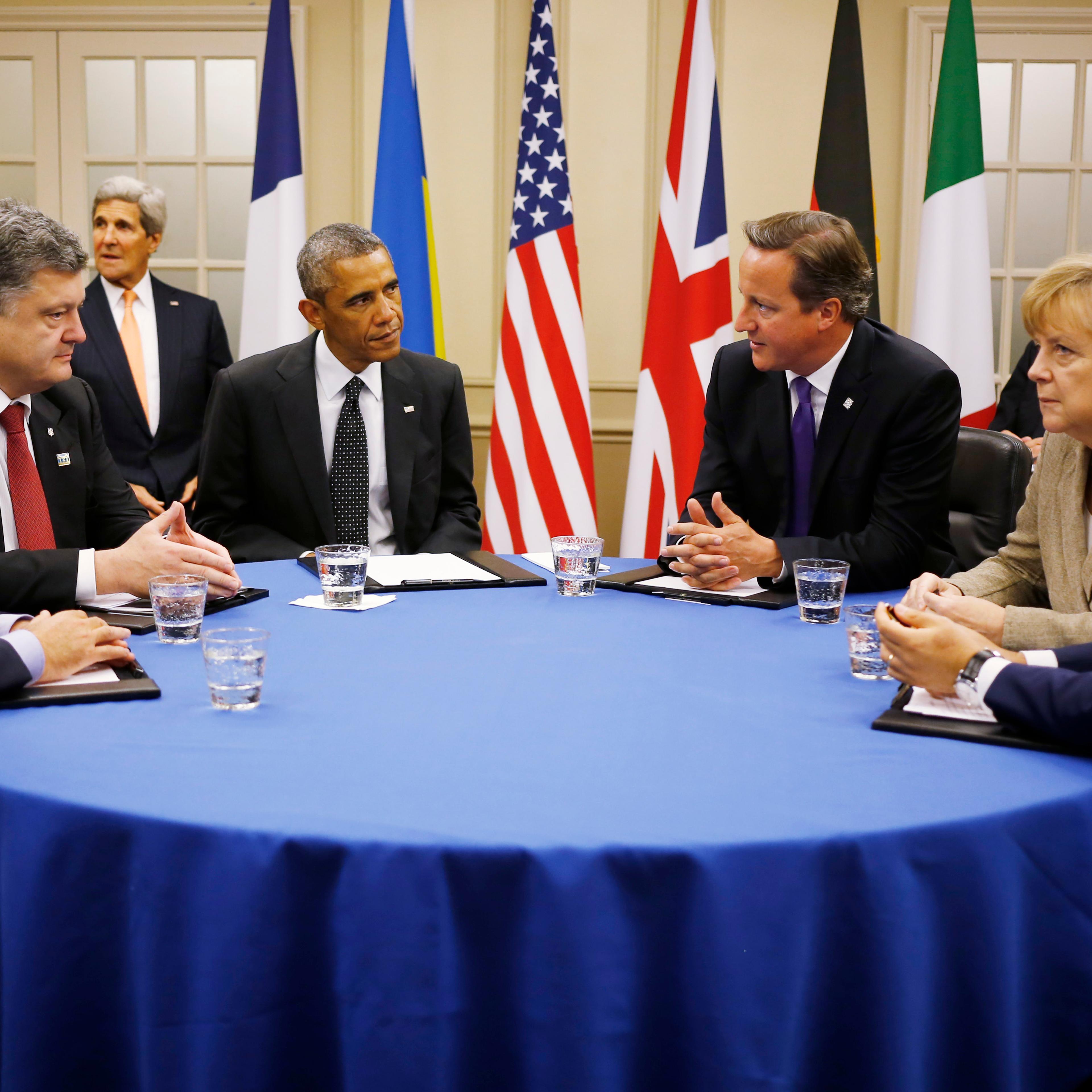 U.S. President Barack Obama is seated at a table with, from left to right: France's President Francois Hollande; Ukraine President Petro Poroshenko; British Prime Minister David Cameron; German Chancellor Angela Merkel; and Italian Prime Minister Matteo