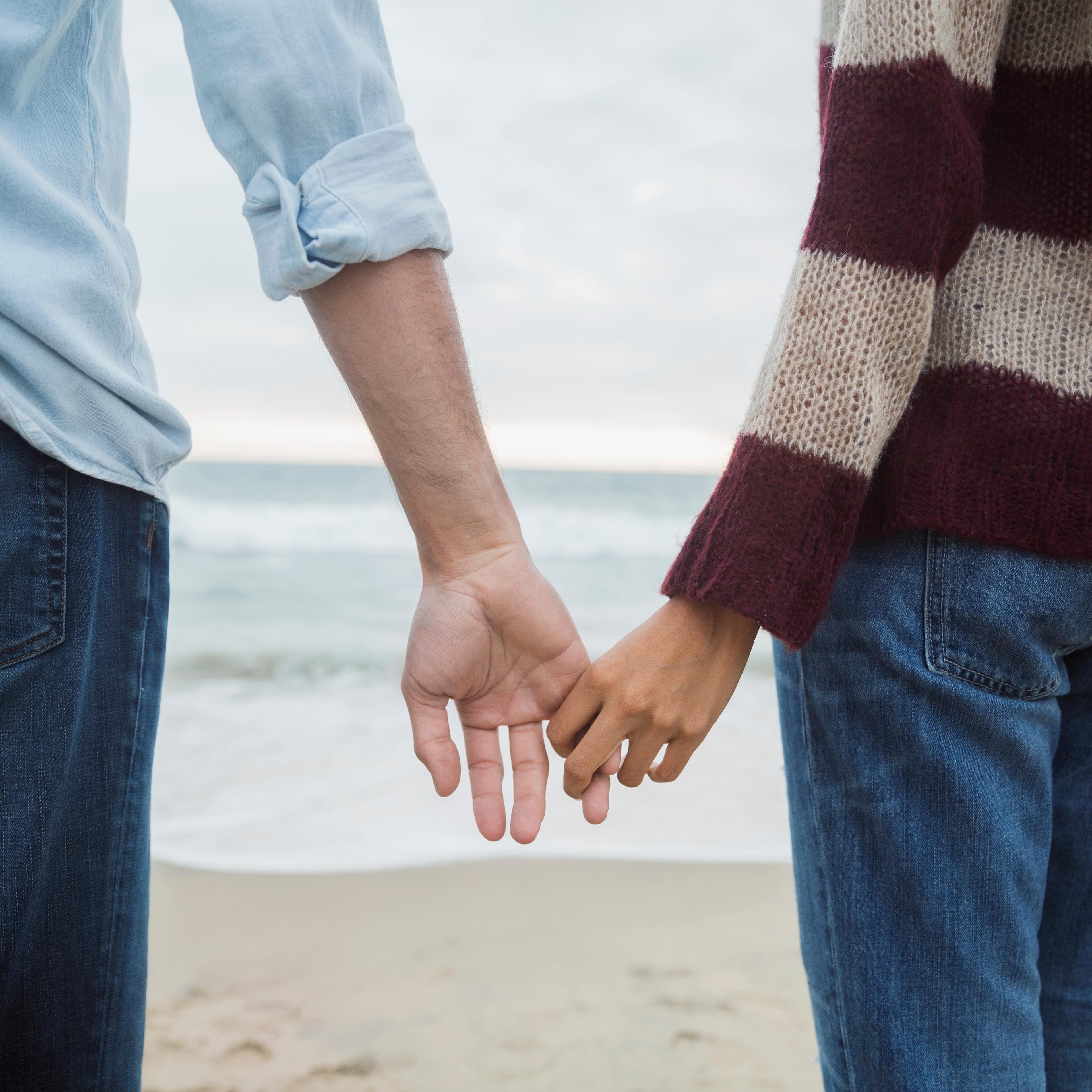 Couple holding hands on beach